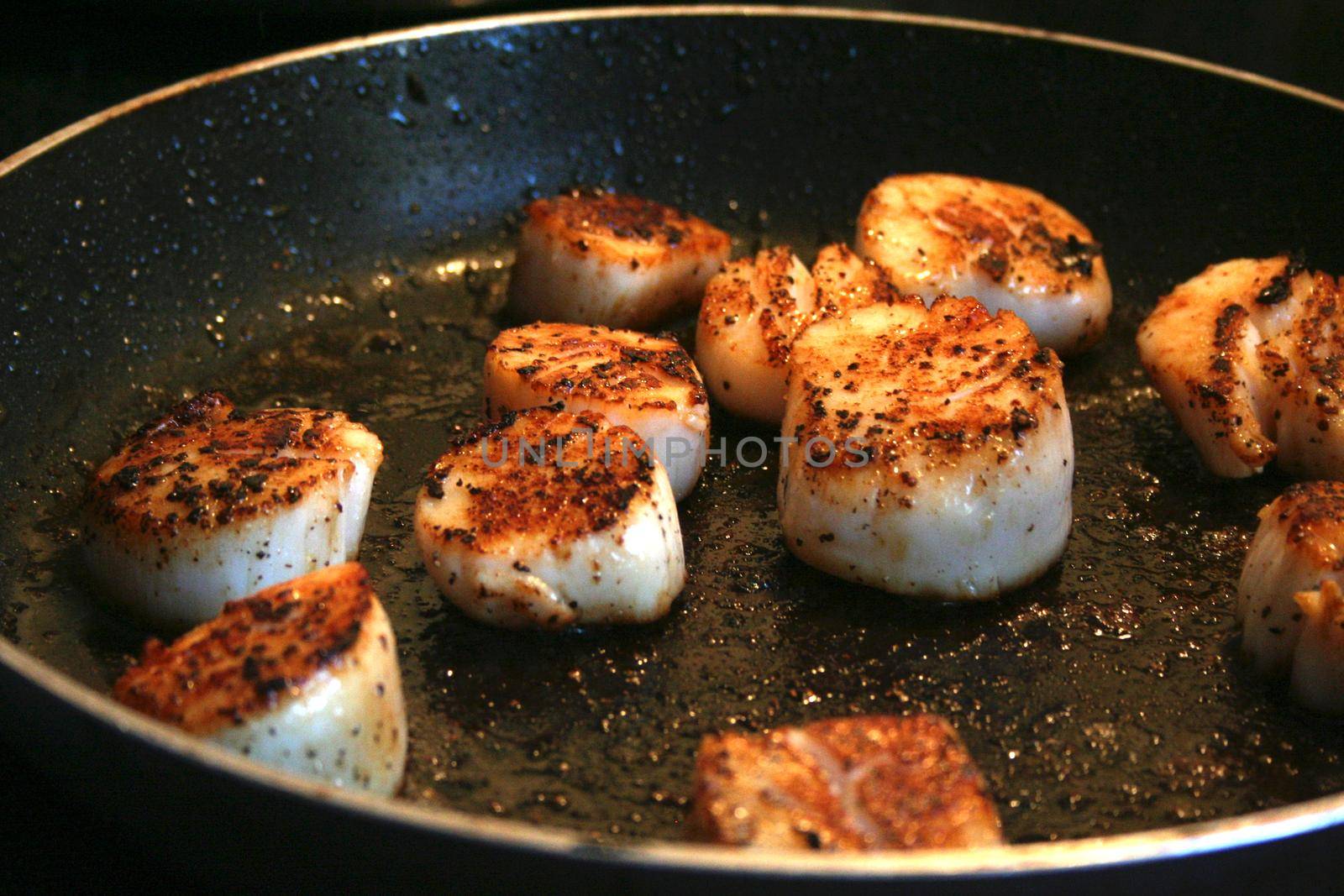 Fried cooked scallops seasoned with salt pepper and spice