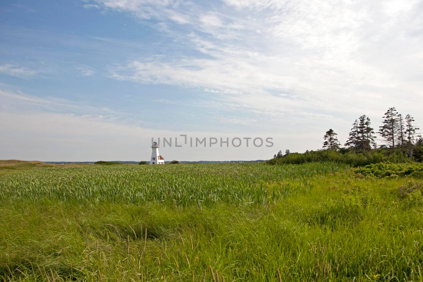 July 27, 2019 - French River, PEI - The landmark lighthouse near the beach in PEI on a summer day on a wide horizon