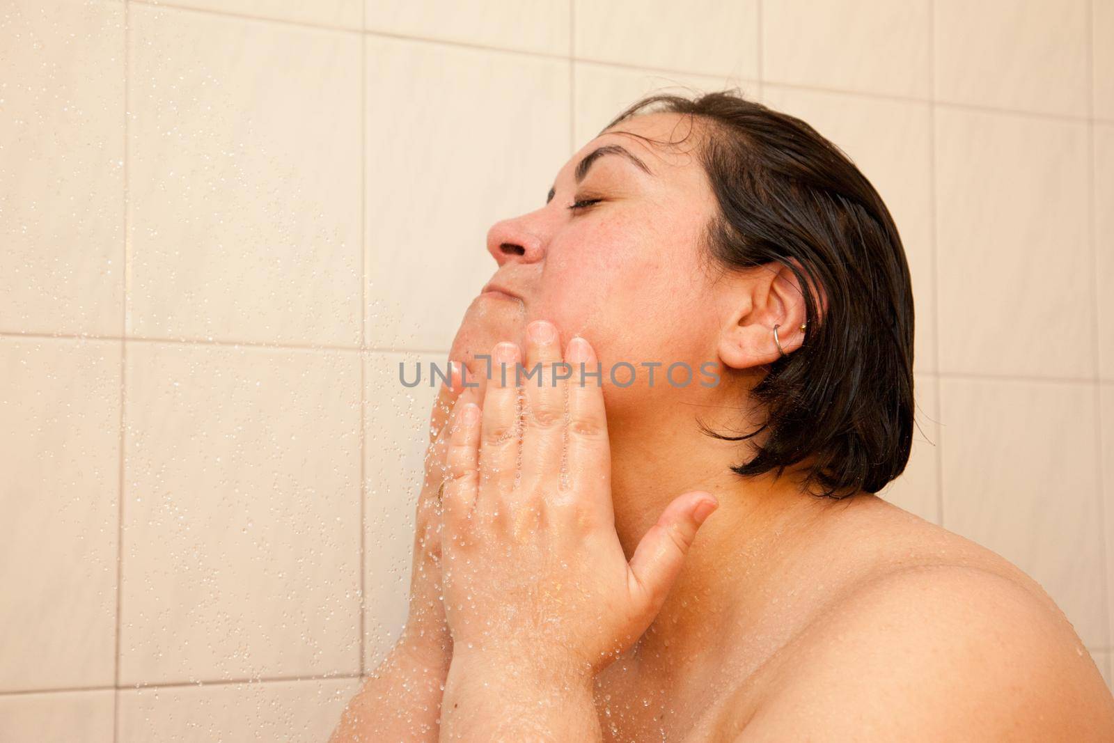 Woman washes face in shower  by rustycanuck