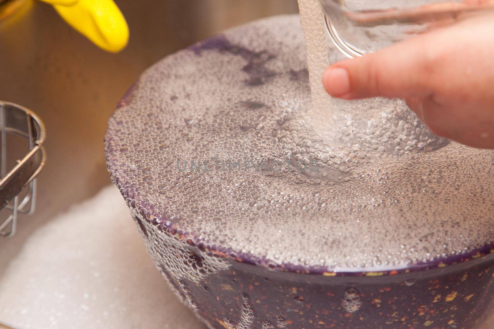 A bowl being washed bubbles up with dish liquid