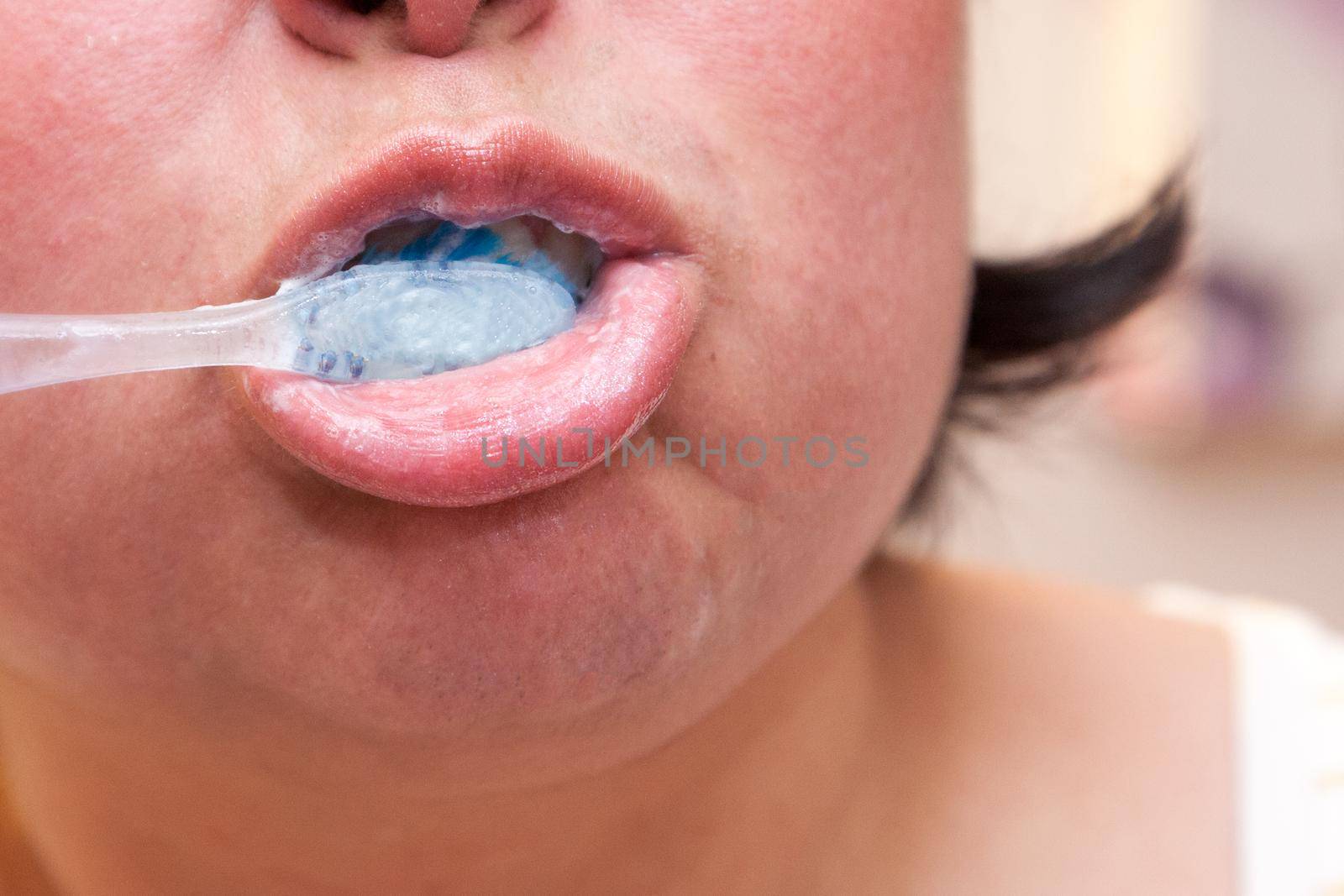 An extremely close view of a mouth and toothbrush 