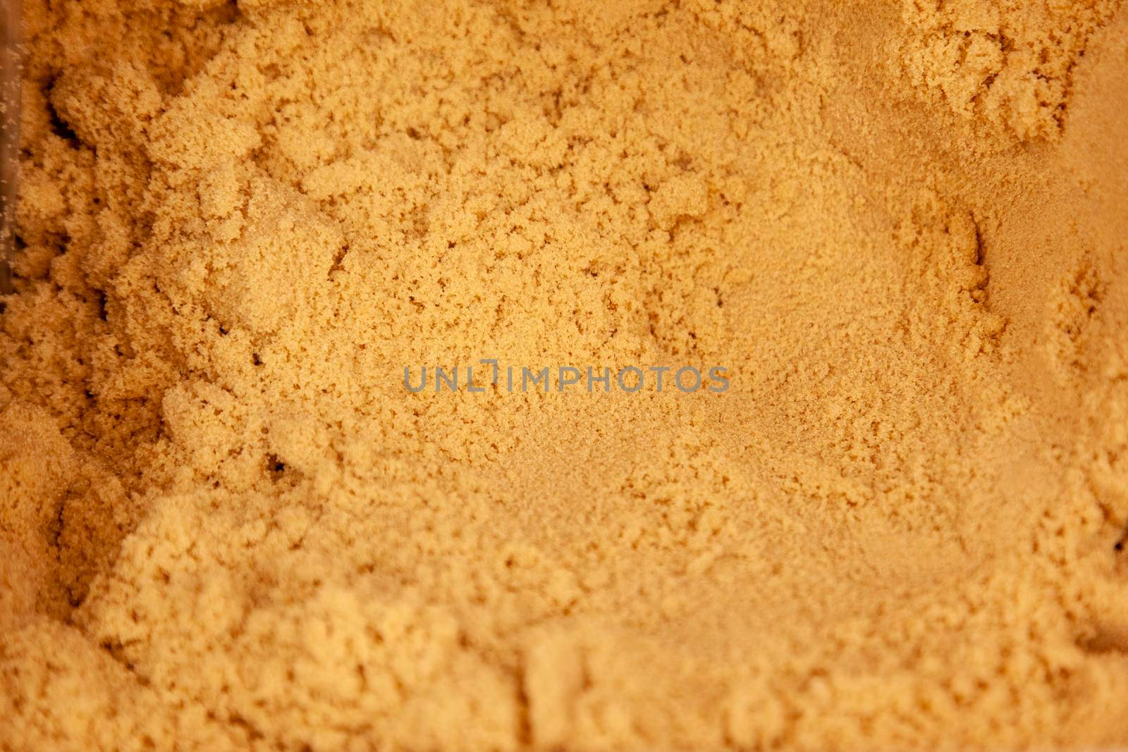 baking ingredient of yellow sugar in a bin ready to be used in a recipe 