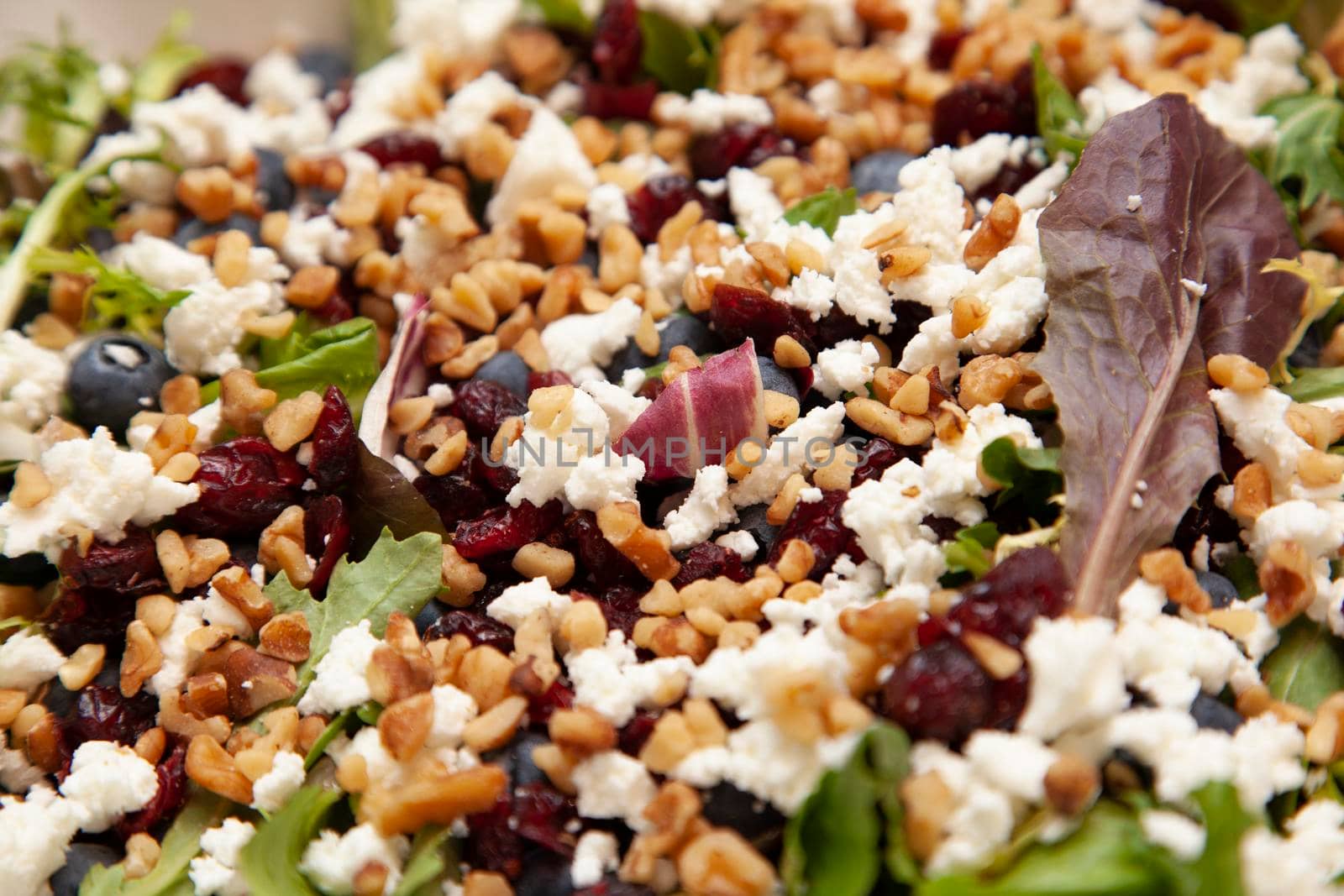 beautiful full looking salad containing feta, blueberries, walnuts and spinach
