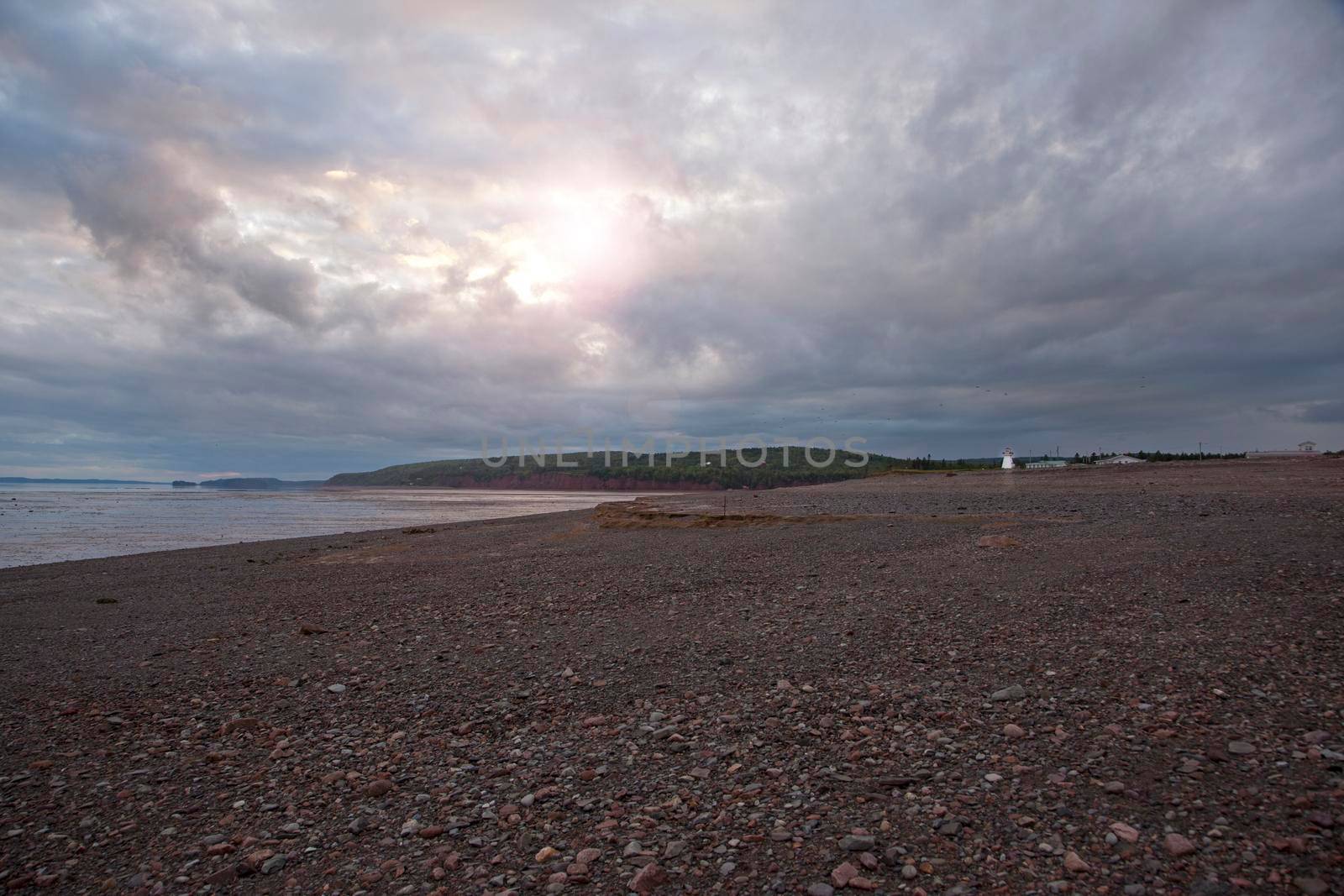 August 18, 2019 - Five Islands, Nova Sctia - gorgeous beach with heavenly sunset with hues of blue and purple in nova scotia with lighthouse 