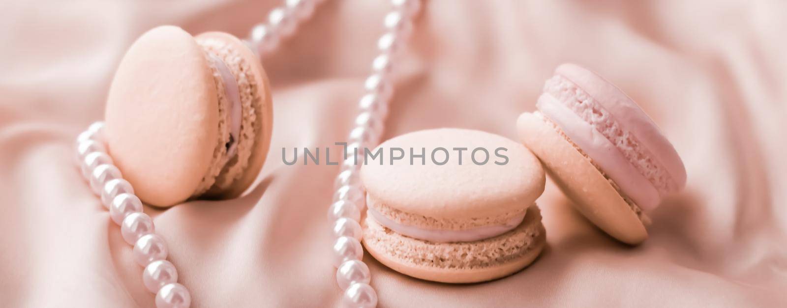 Sweet macaroons and pearls jewellery on silk background, parisian chic jewelry, French dessert food and cake macaron for luxury confectionery brand, holiday gift by Anneleven