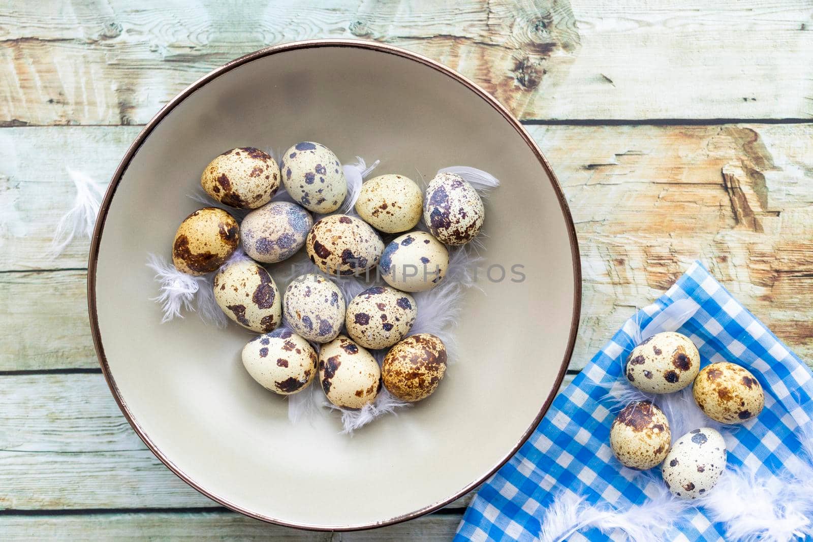 Quail eggs inside a decorative plate and on a background