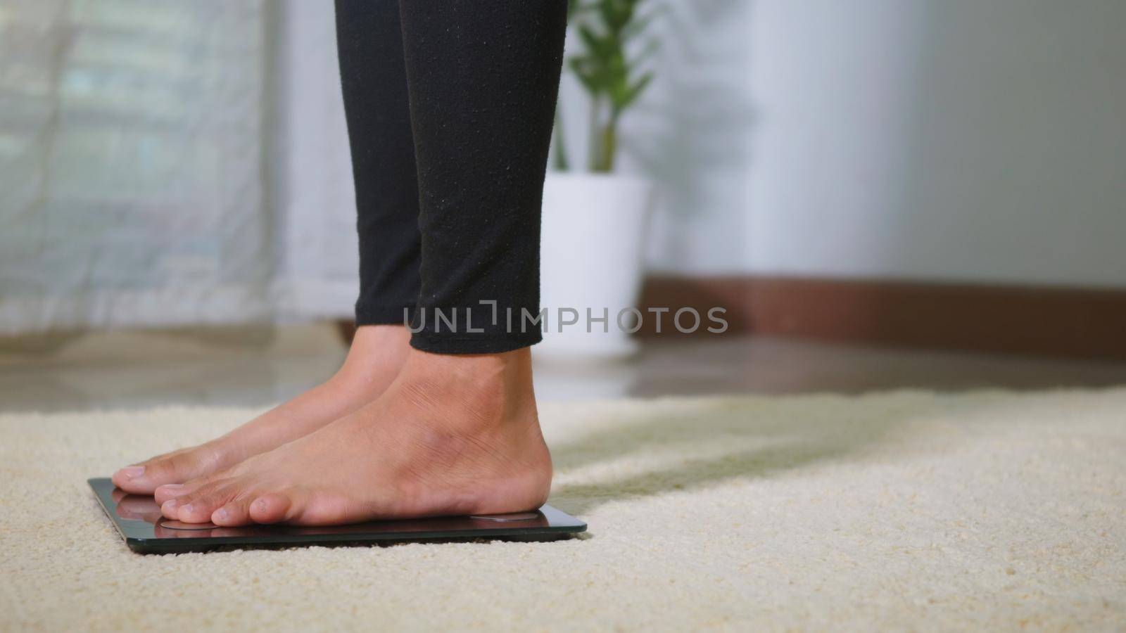 woman leg stepping standing on floor electric scales by Sorapop