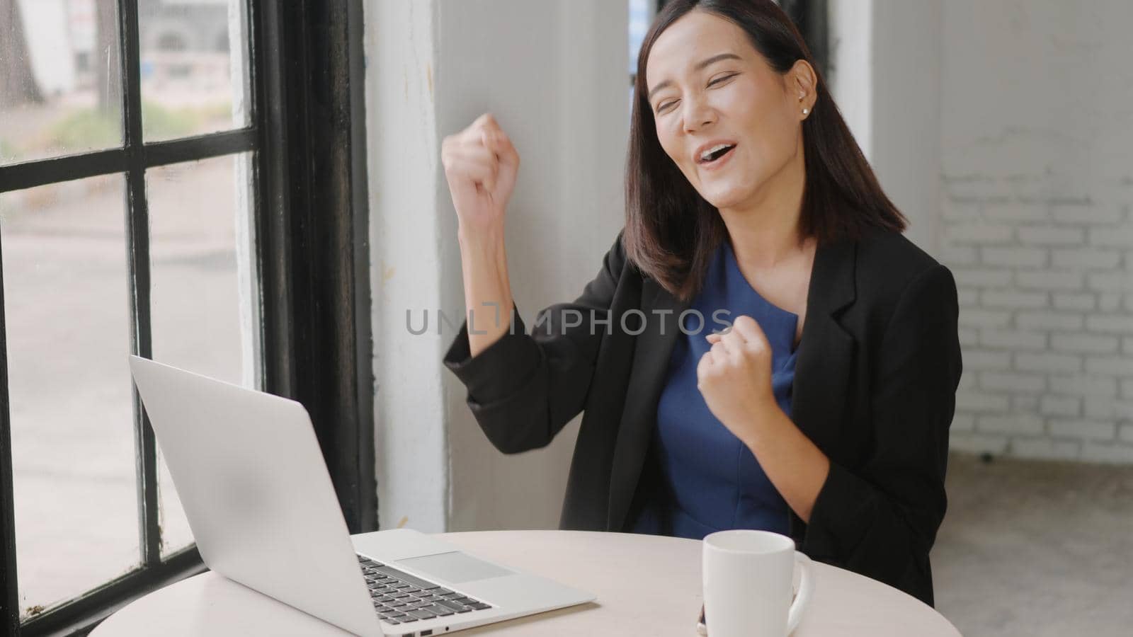 Yes! Happy excited successful, Asian businesswoman smile workstation triumphing with raised hands with laptop computer, woman success project online winner
