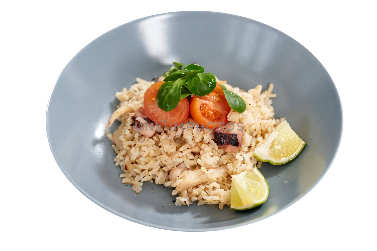 Close up of beautiful blue bowl with rice, tasty seafood, juicy tomatoes and two pieces limes on white background. Concept of food with all vitamins for health.