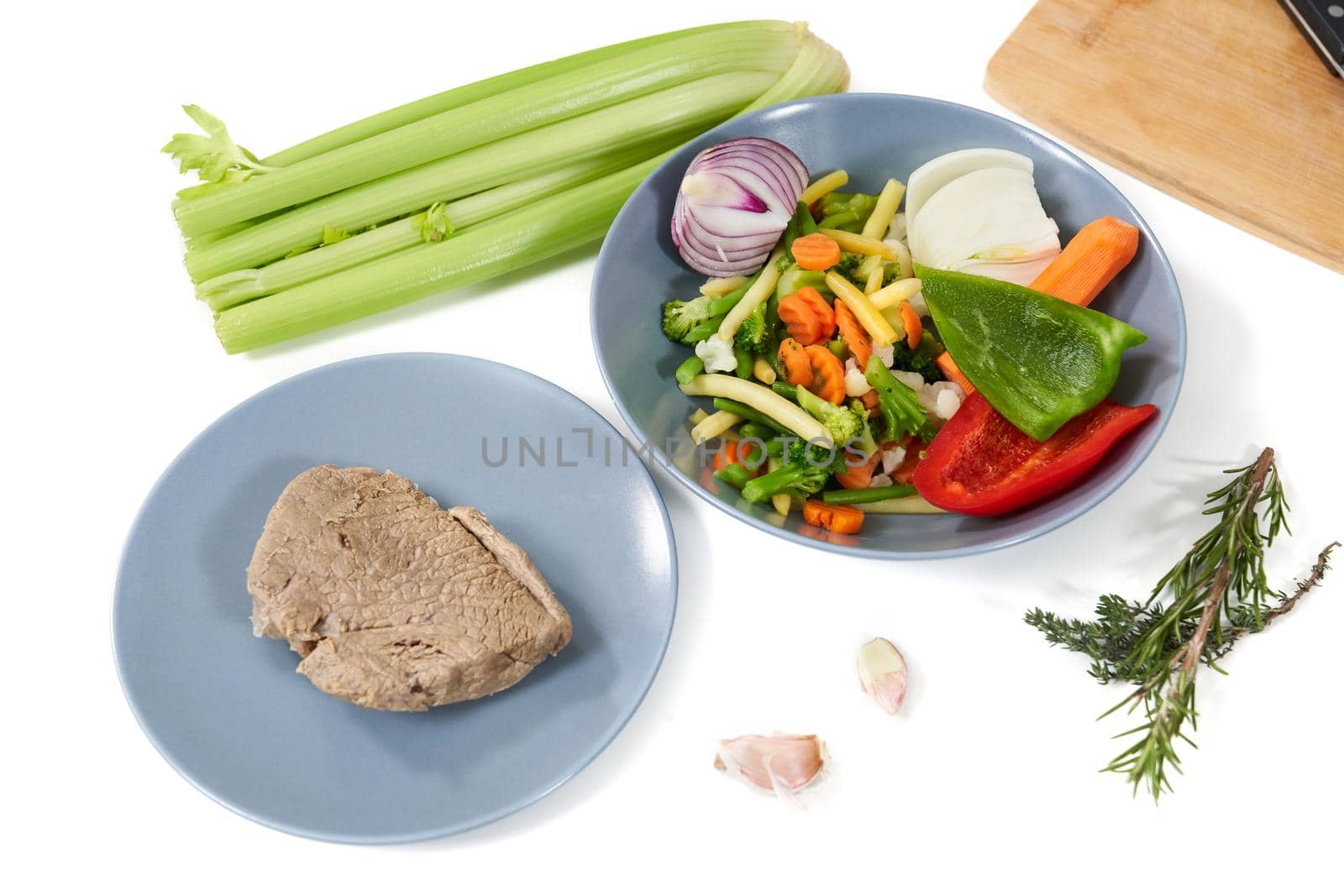 Top view of delicious boiled meat and different vegetables on table for tasty dish. Concept of cooking yummy meal with healthy ingredients garlic,rosemary,celery,colorful vegetables. 