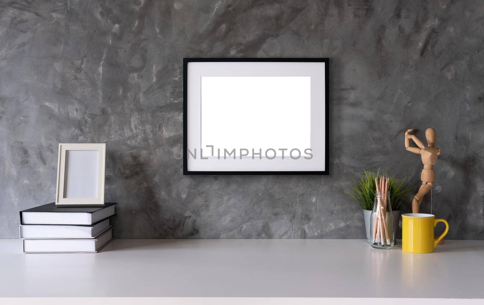 White desk with photo frame, office supplies, book natural leaf inin design vase.