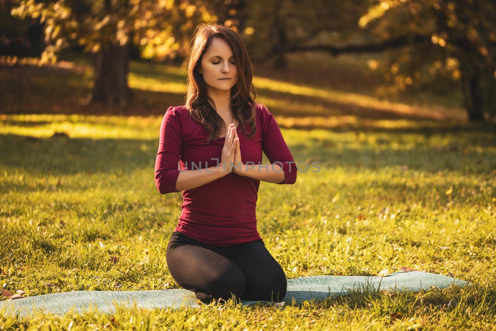 Woman sitting in nature and meditating by Bazdar