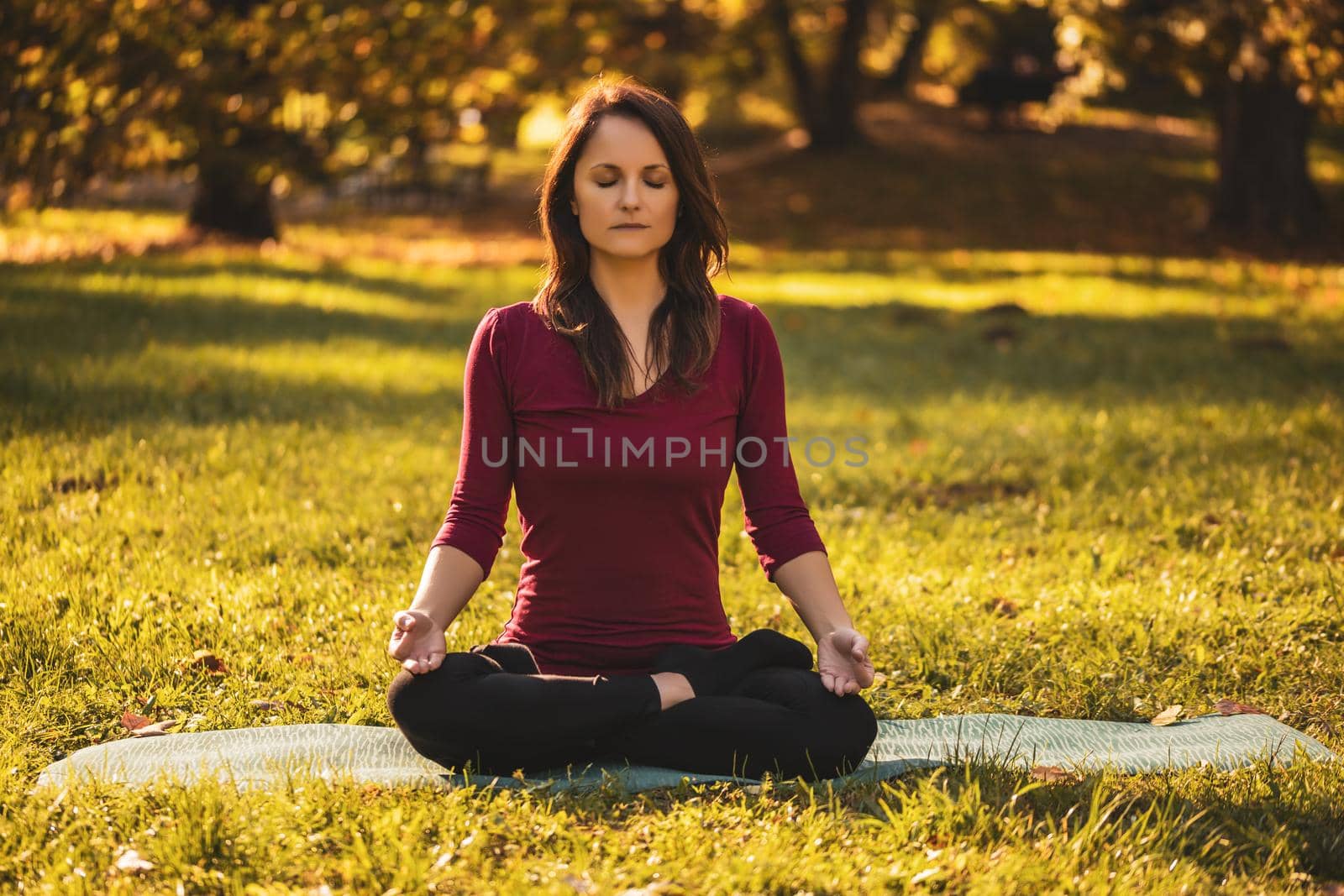 Woman sitting in lotus position and meditating by Bazdar