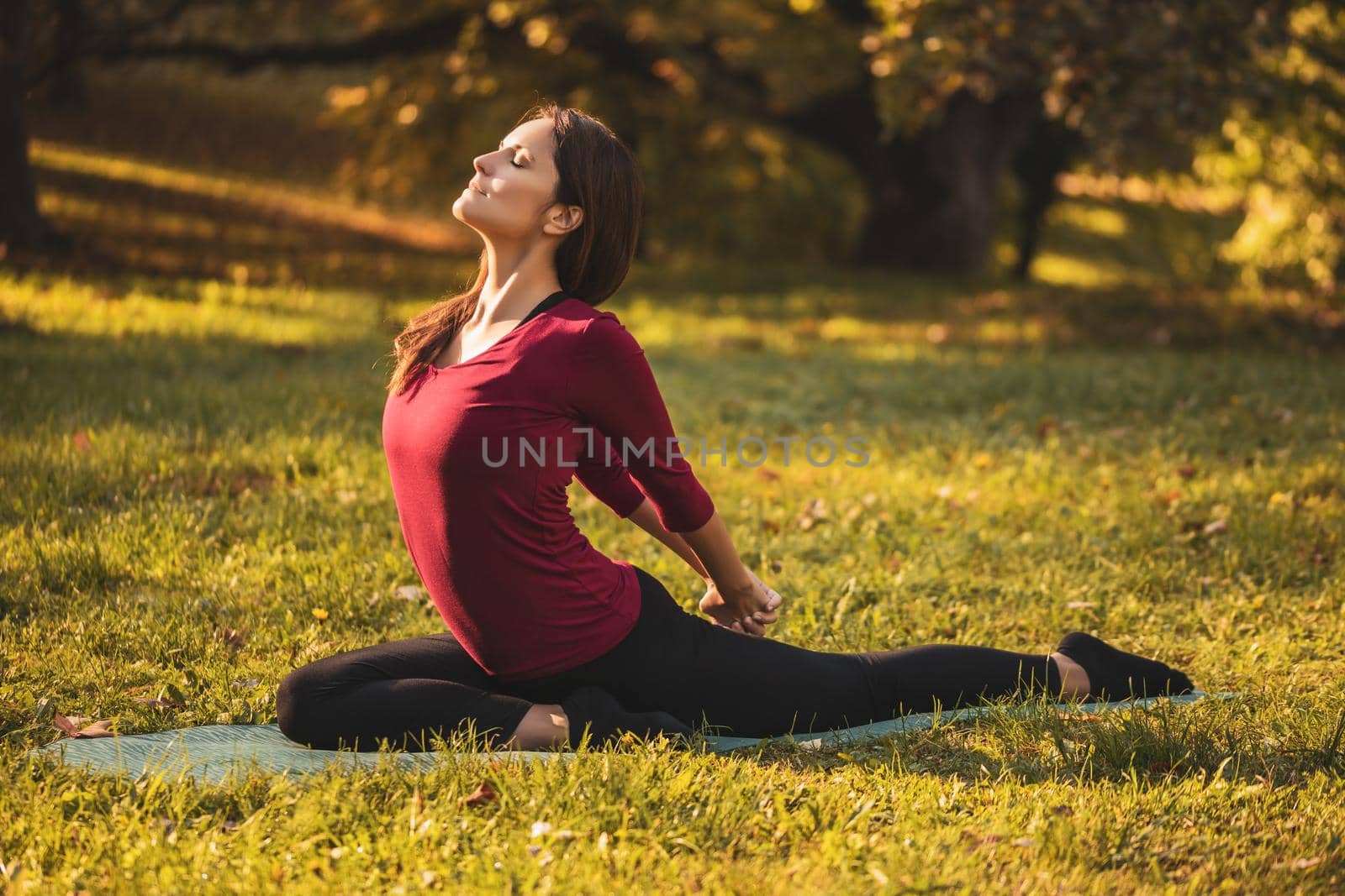 Beautiful woman doing yoga in the nature,variation of Salabhasana/Locust Pose