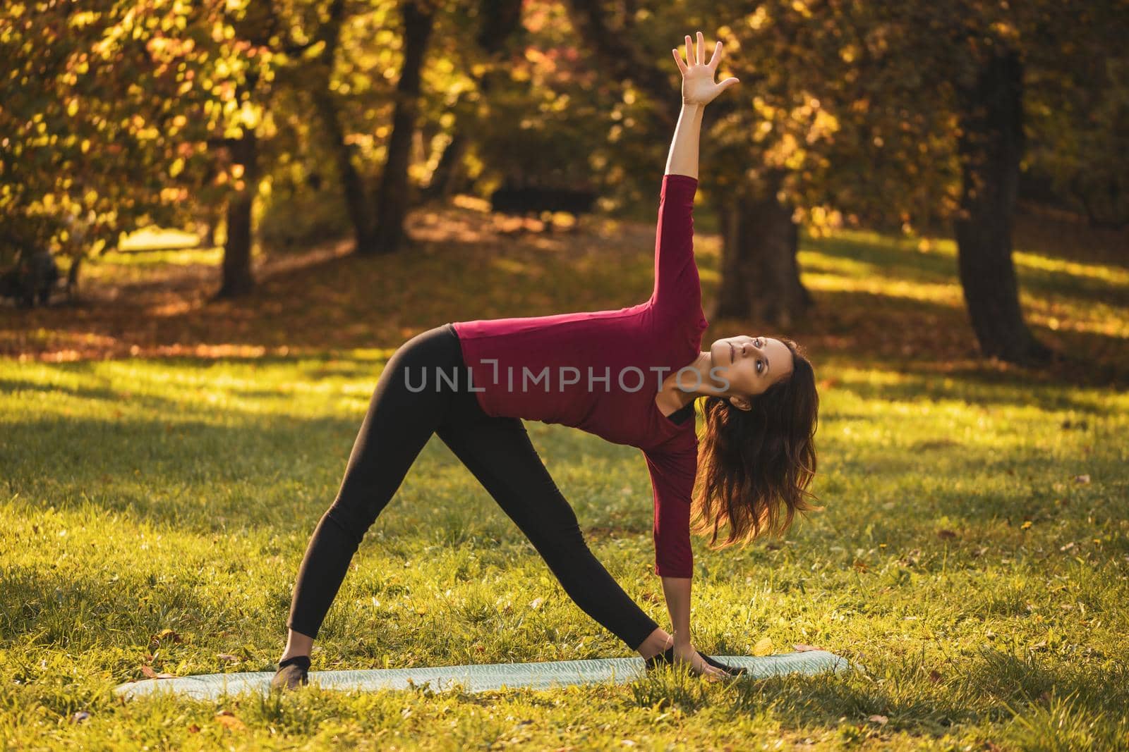 Beautiful woman doing yoga in the nature,Trikonasana/Triangle pose