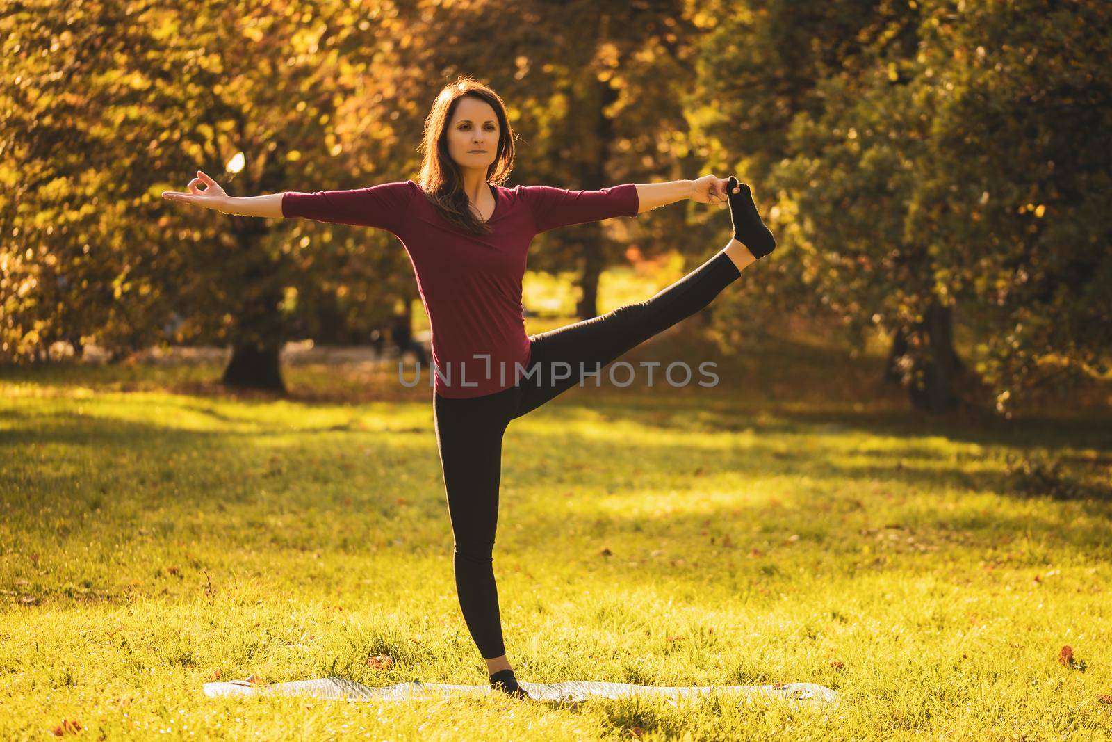 Beautiful woman doing yoga in the nature,Utthita Hasta Padangustasana /Hand to Big Toe pose
