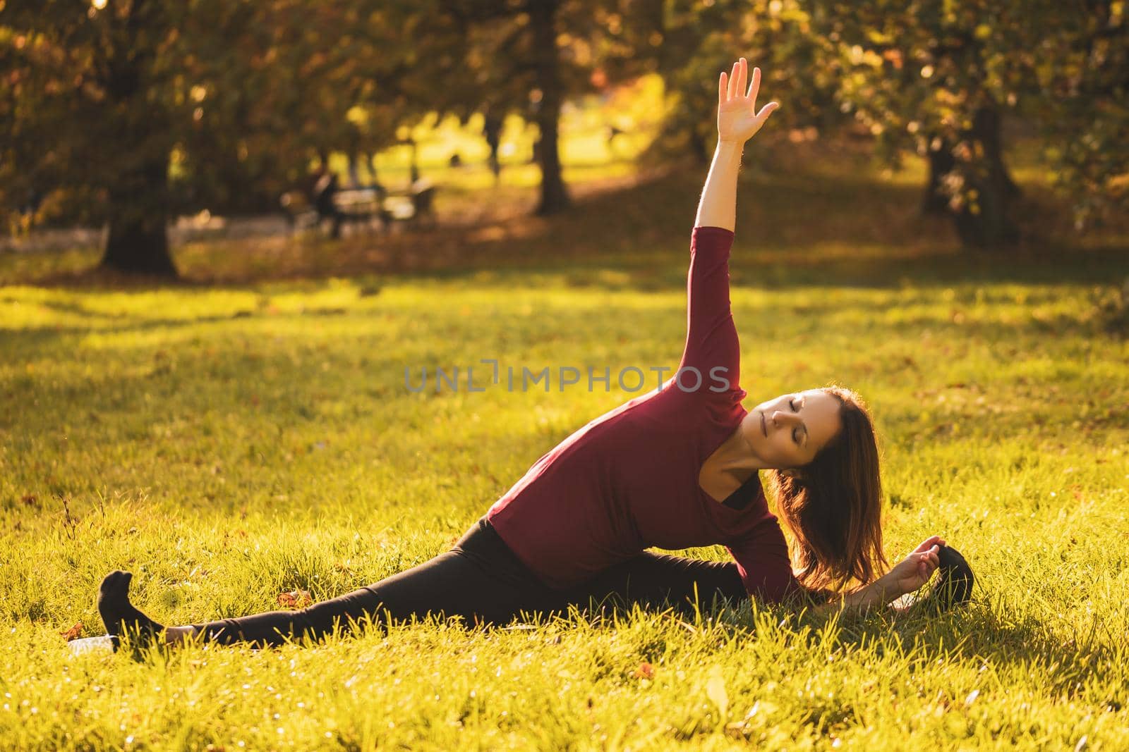 Beautiful woman doing yoga in the nature,variation of Parivrtta Janu Sirsasana/Revolved Head-to-Knee Pose