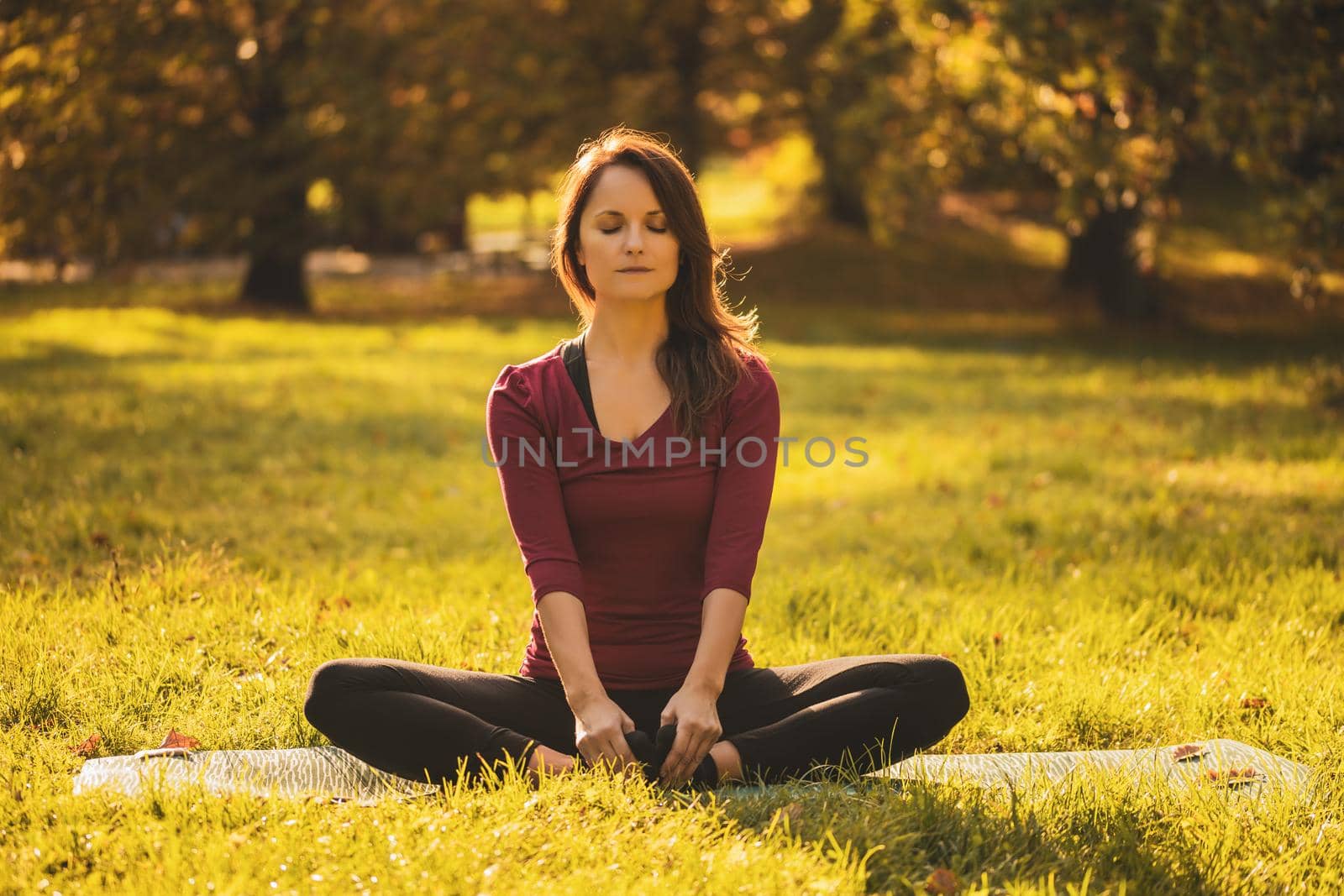 Beautiful woman sitting in lotus position and meditating in the nature,Padmasana/Lotus position.