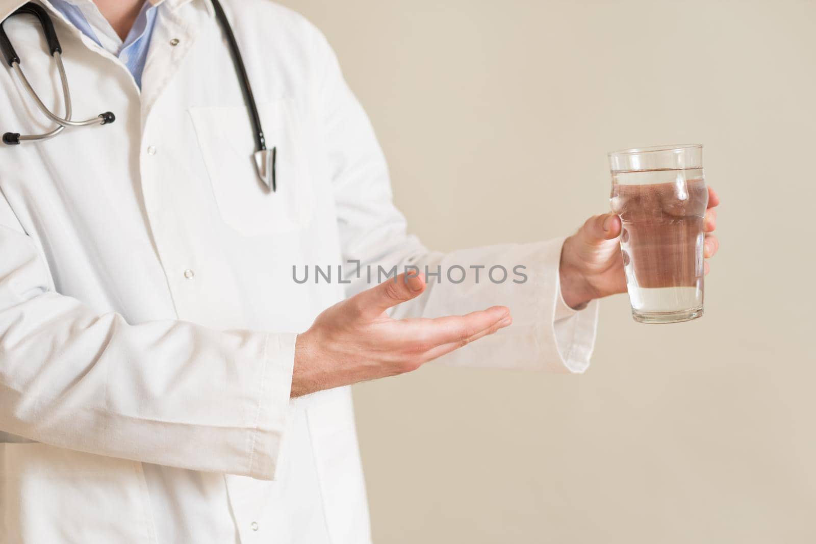 Male doctor showing on glass of water by Bazdar