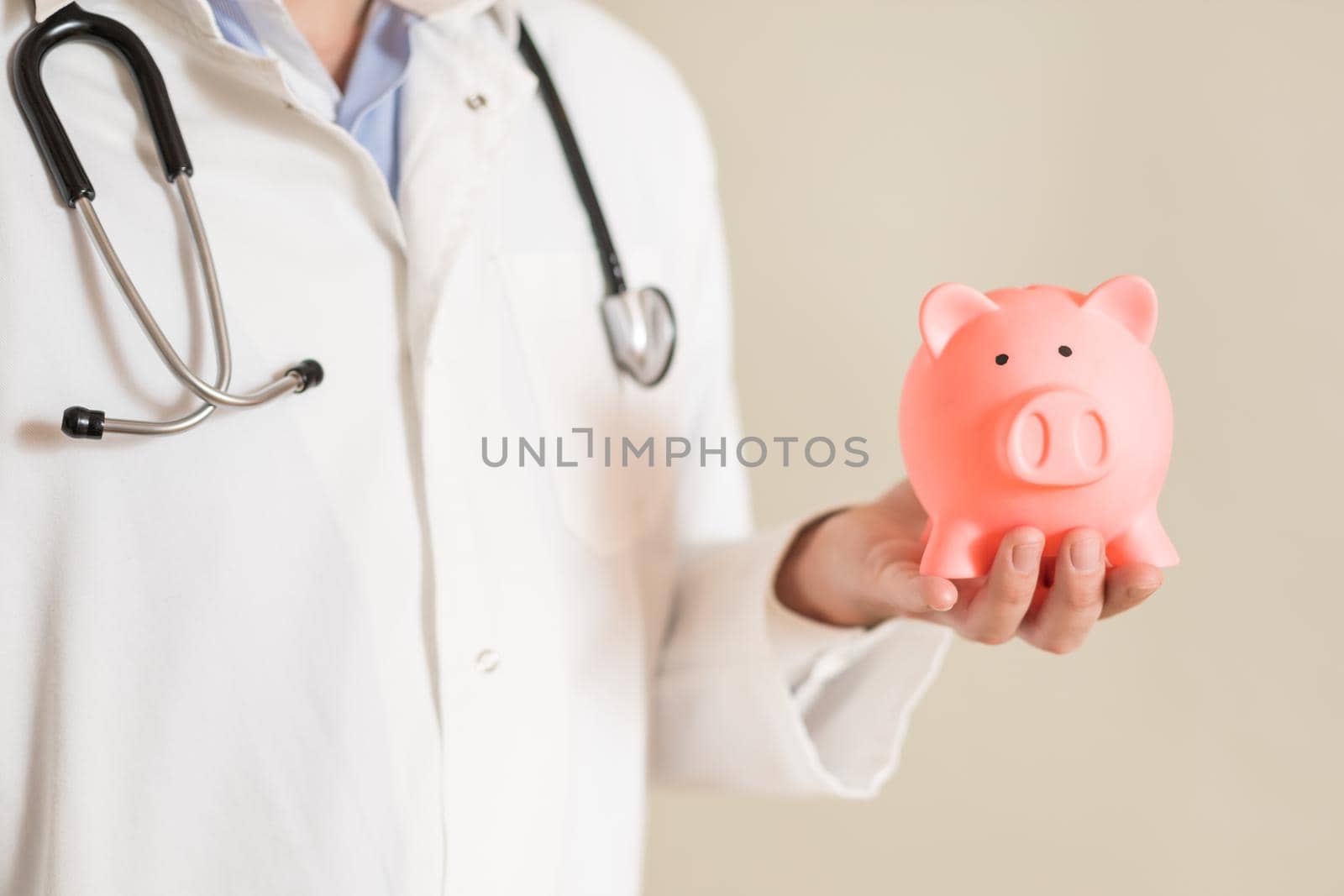 Male doctor holding piggy bank by Bazdar