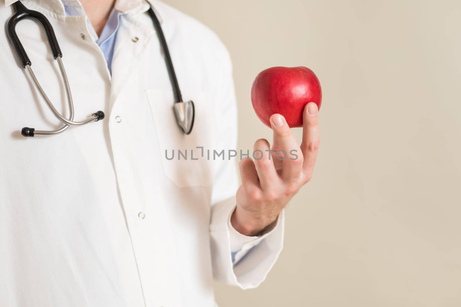 Image of male doctor holding apple.