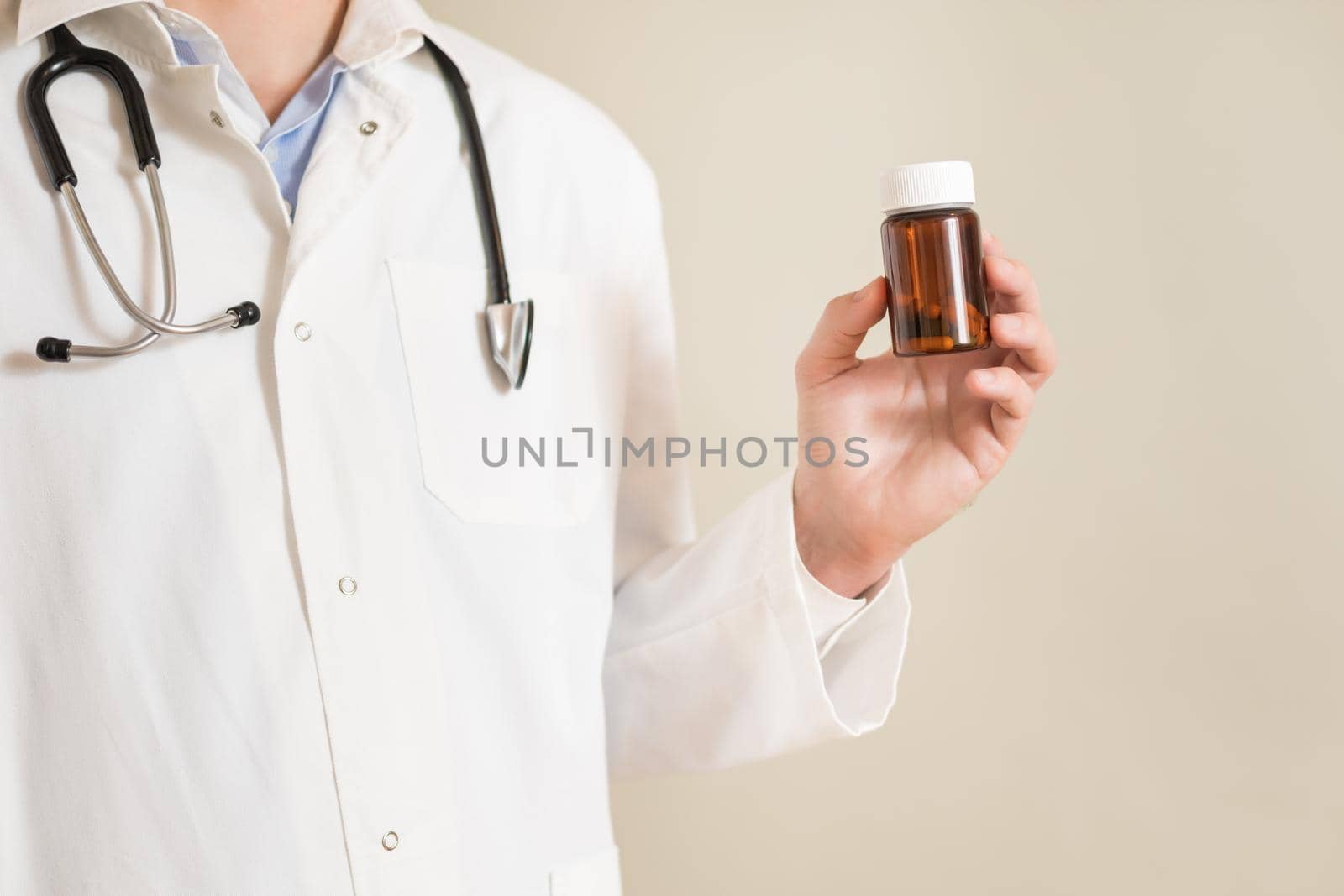 Male  doctor holding bottle of pills by Bazdar