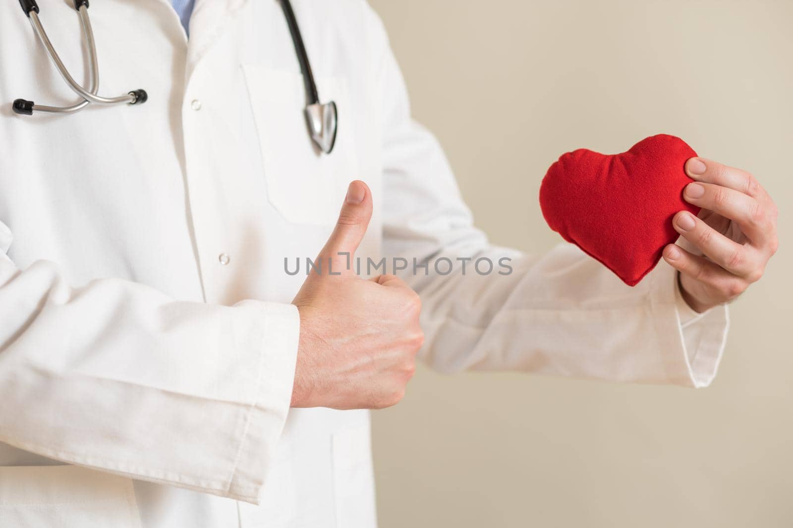 Image of  male doctor showing heart shape and thumb up.
