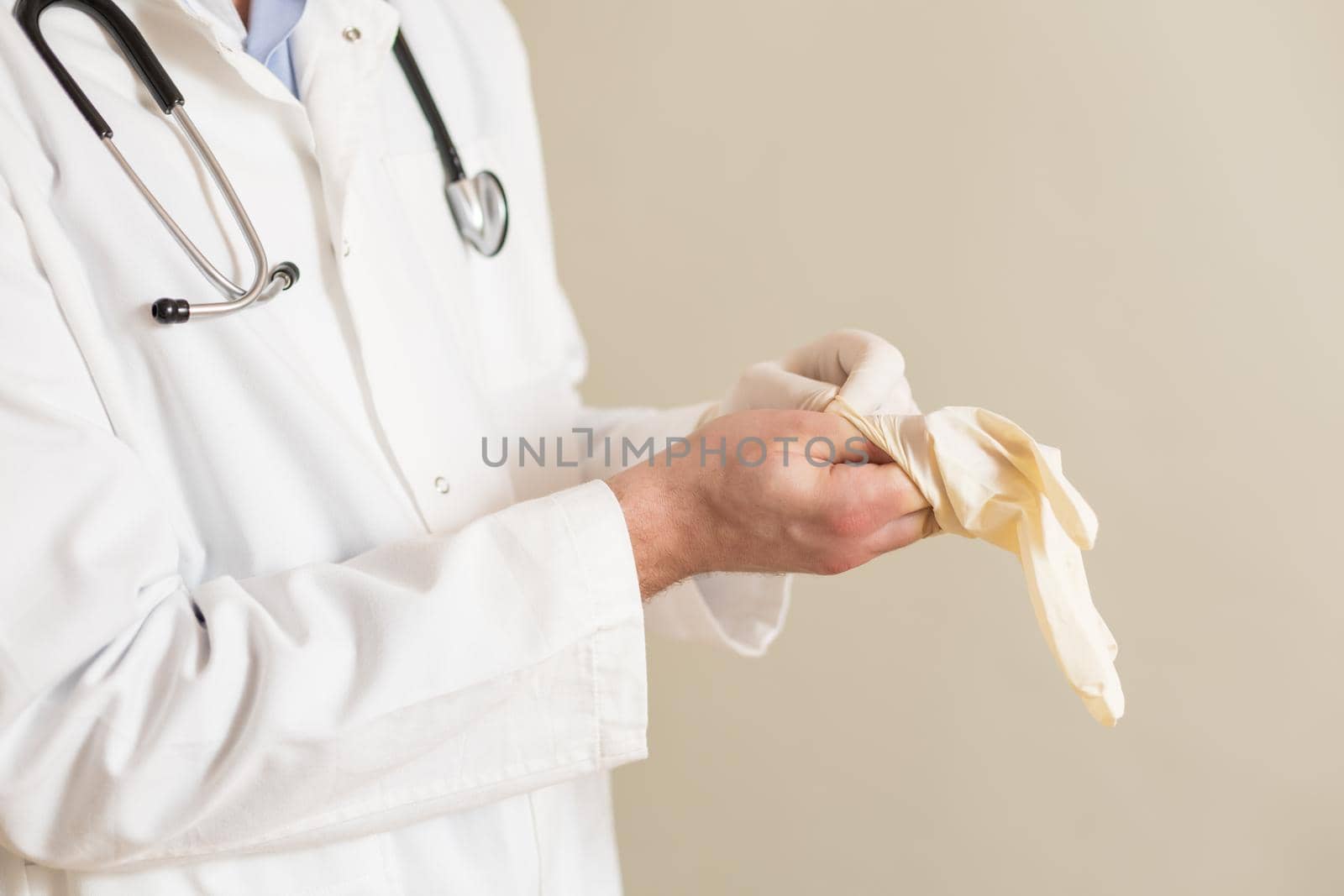 Male doctor putting on protective gloves by Bazdar
