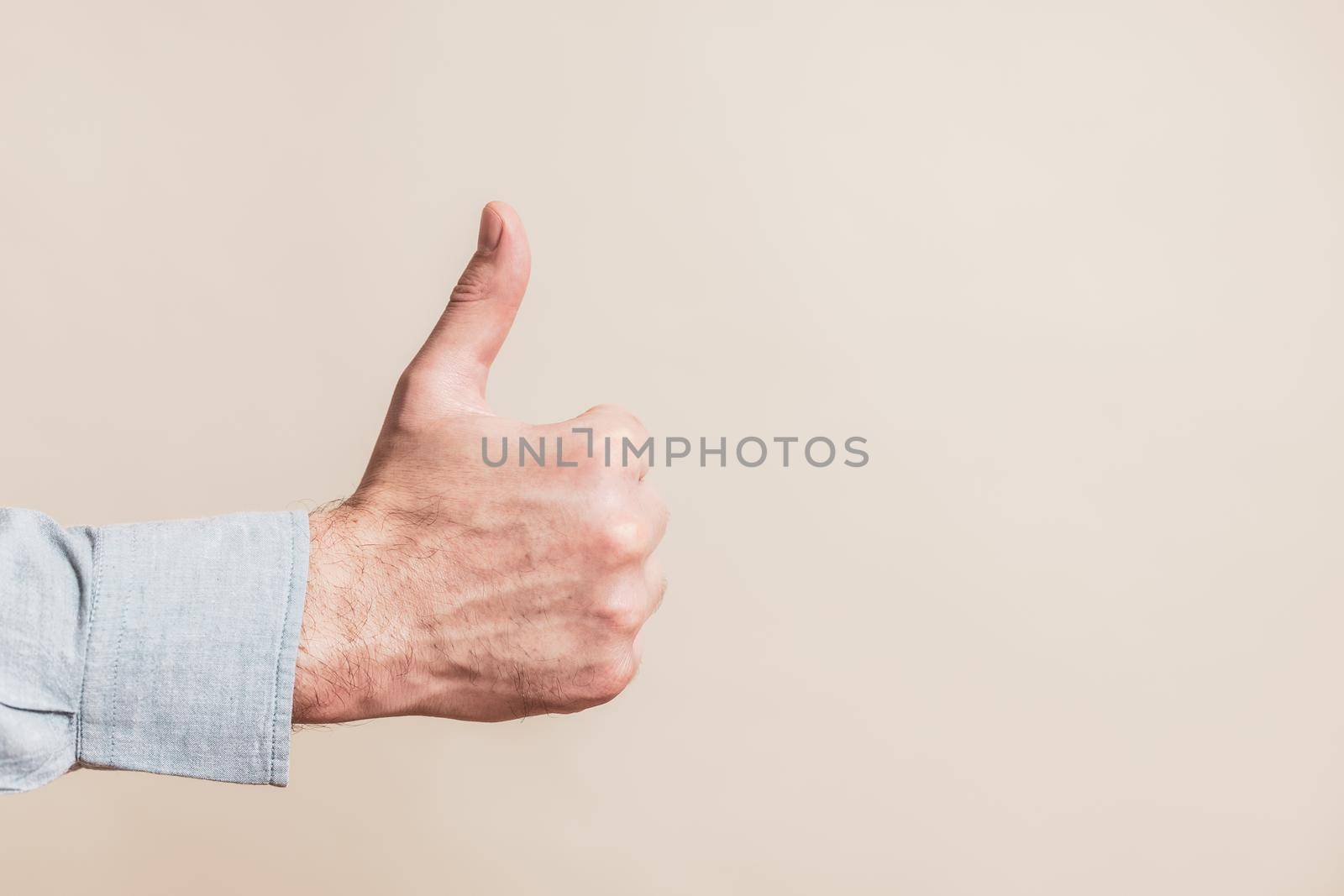 Close up image of male hand showing thumb up.