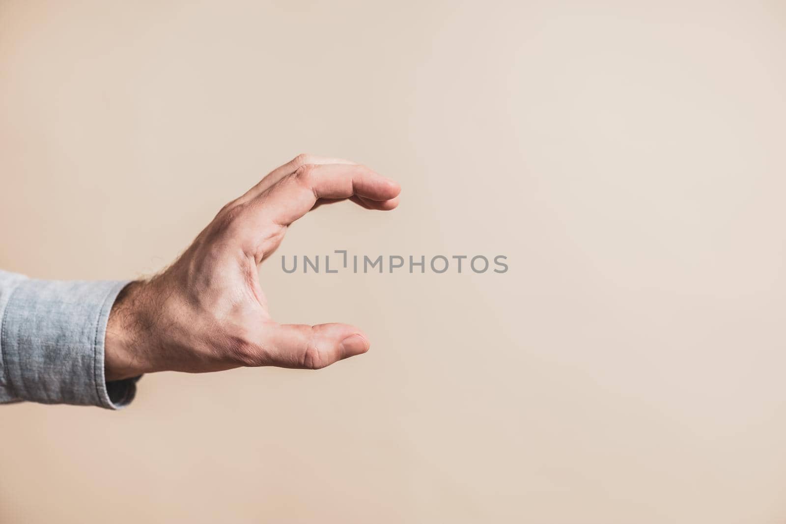 Close up image of male hand in holding gesture.