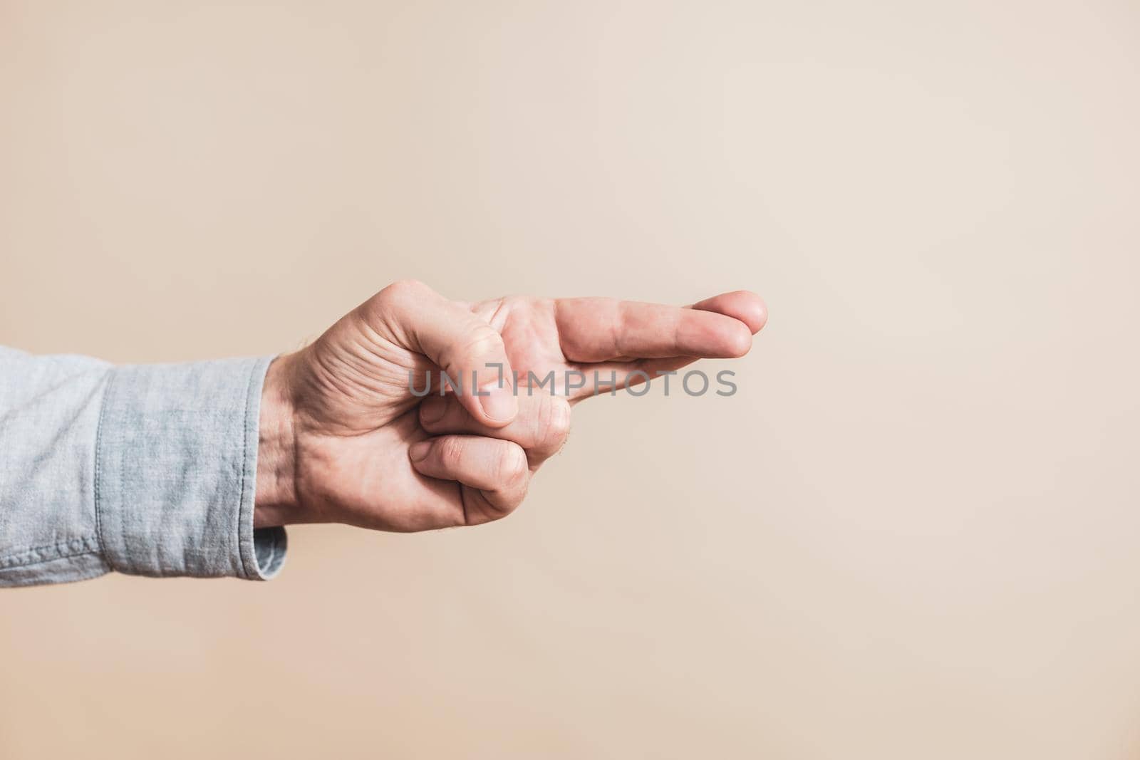 Close up image of  male hand with  crossing two finger gesture.