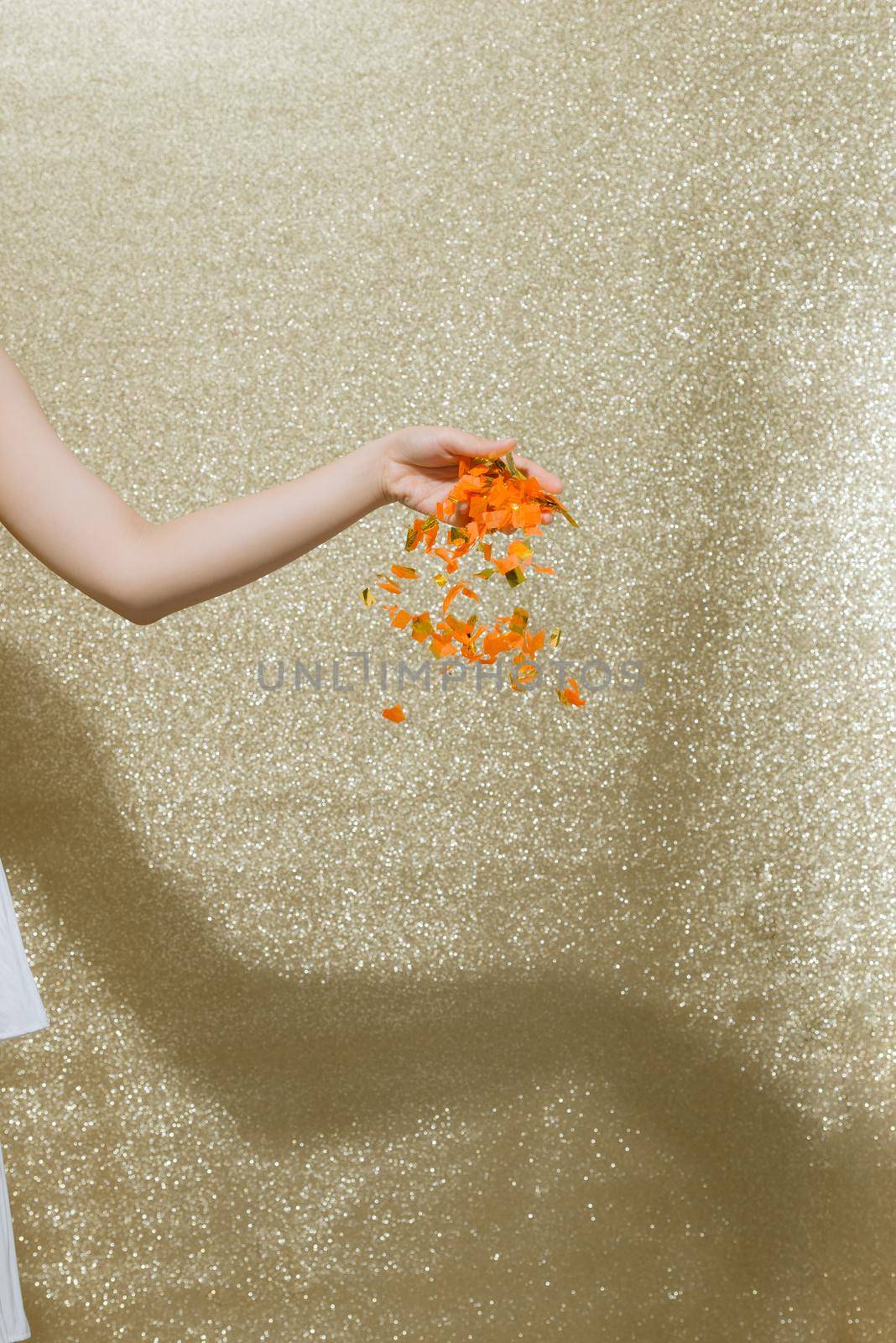 Colored confetti flying on gold background