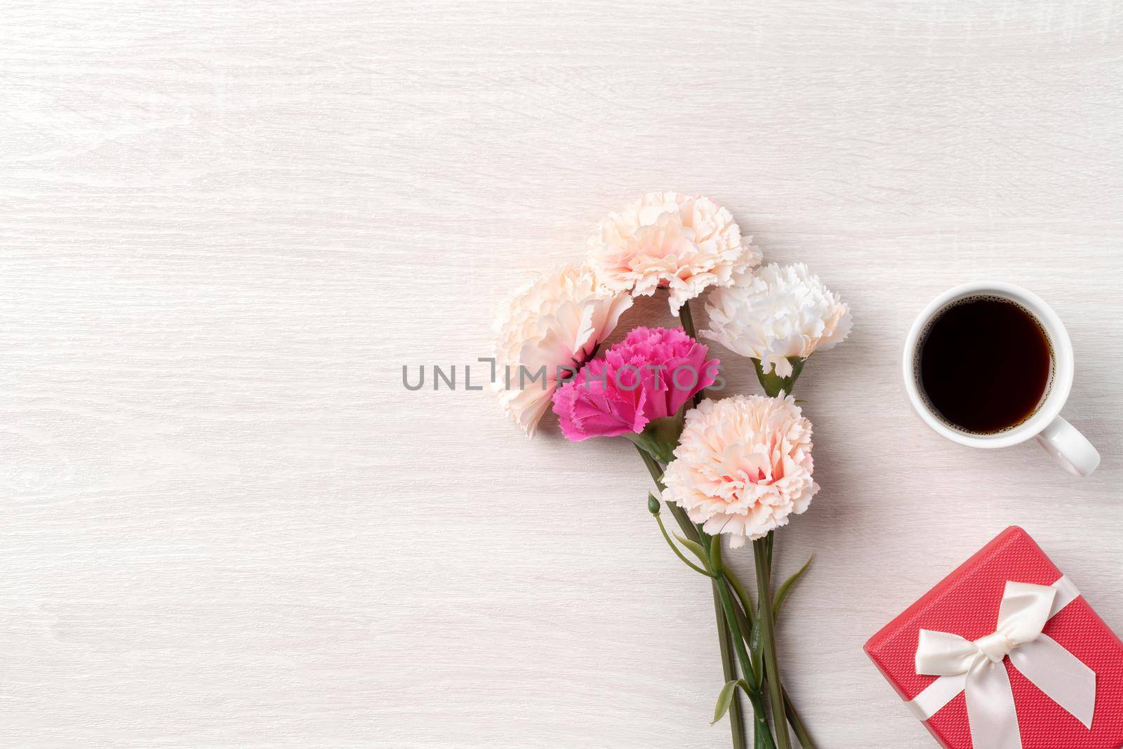 Mother's Day design concept. Top view of beautiful carnation flower and holiday gift idea with copy space.