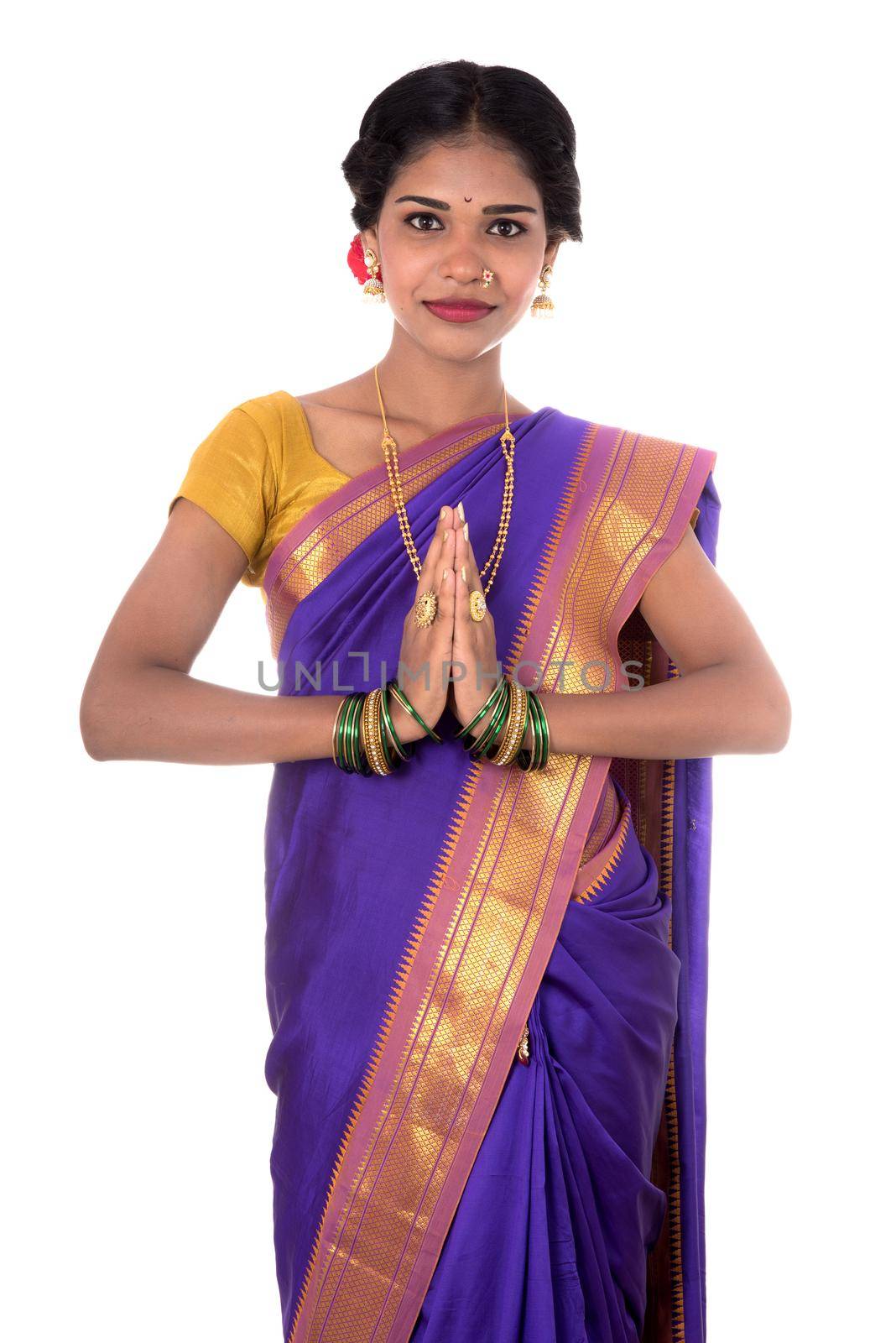 Young Indian girl in traditional clothing greeting namaste, Welcome, Indian girl in a tradition sari with welcome expression (inviting) by DipakShelare