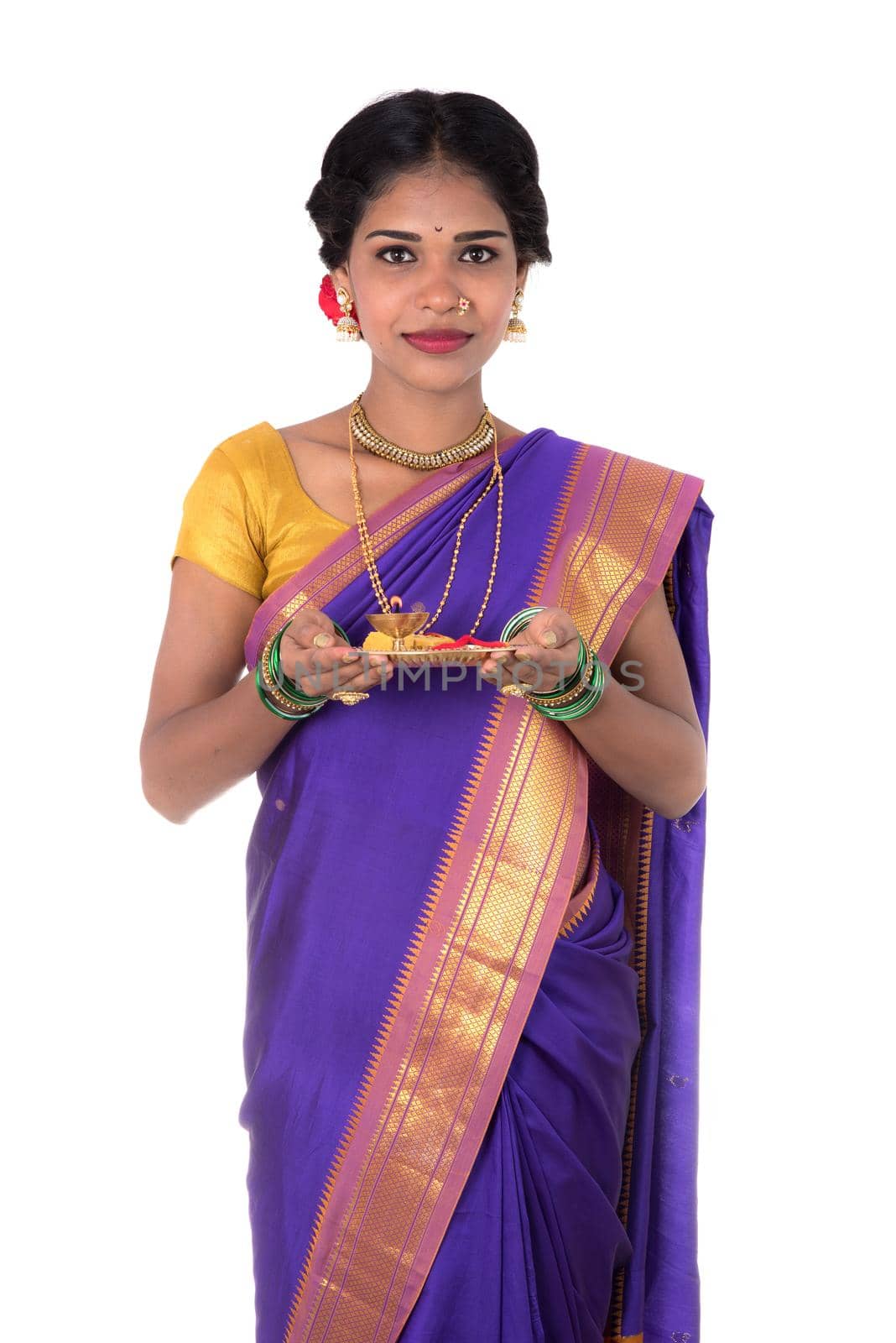 Indian woman performing worship, portrait of a beautiful young lady with pooja thali isolated on white background