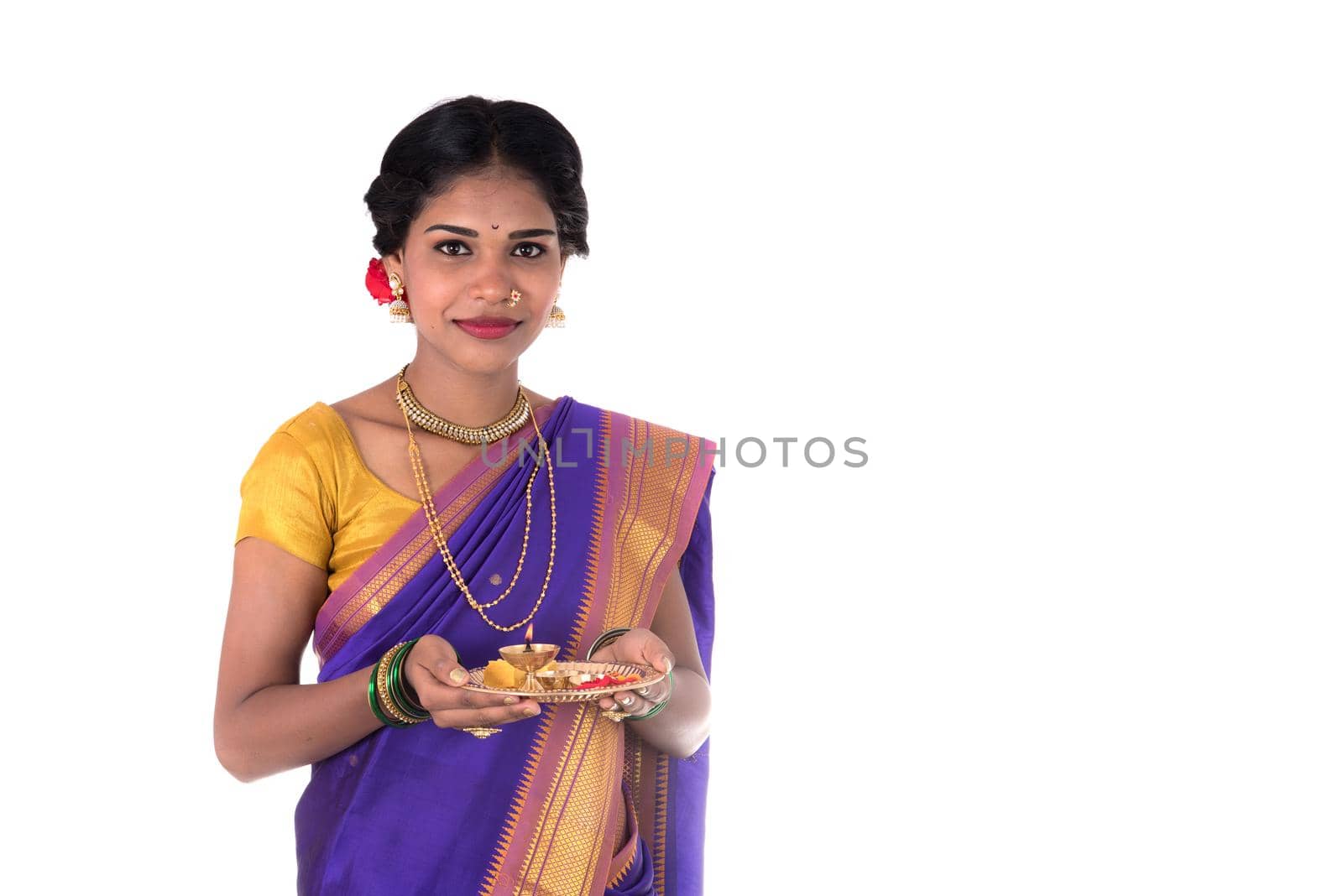 Indian woman performing worship, portrait of a beautiful young lady with pooja thali isolated on white background