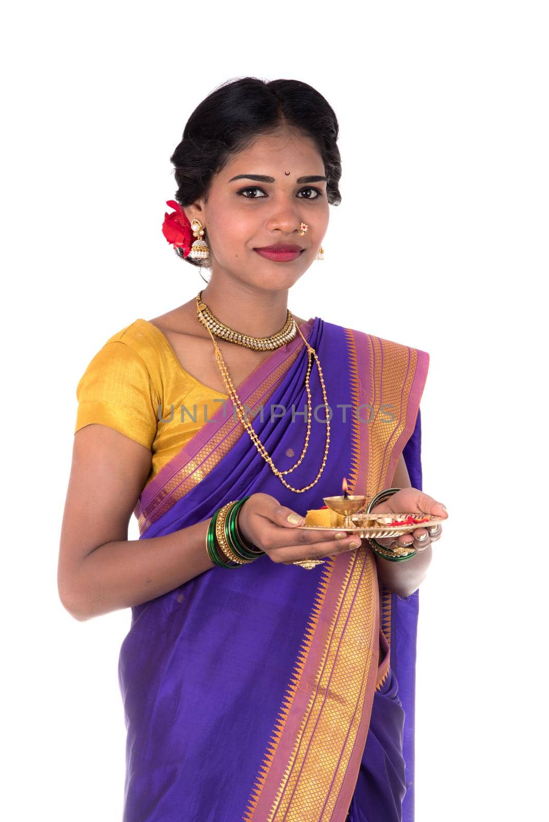 Indian woman performing worship, portrait of a beautiful young lady with pooja thali isolated on white background