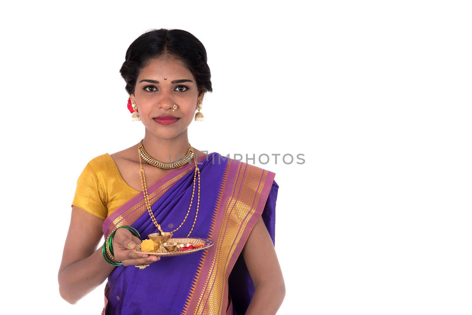 Indian woman performing worship, portrait of a beautiful young lady with pooja thali isolated on white background