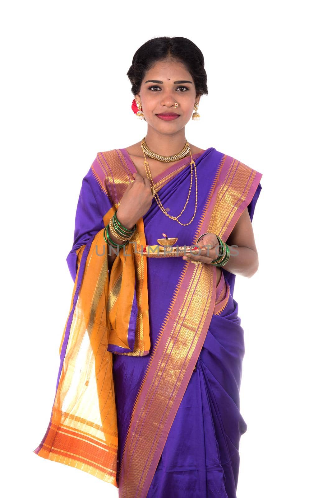 Indian woman performing worship, portrait of a beautiful young lady with pooja thali isolated on white background