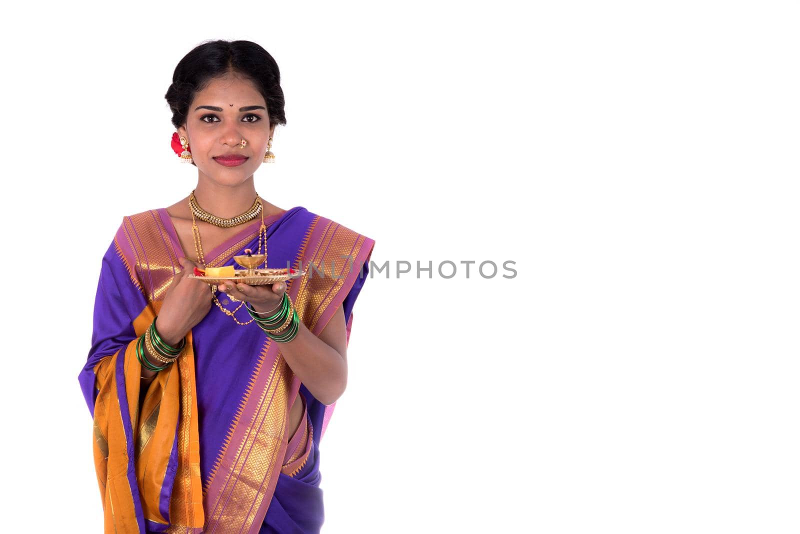 Indian woman performing worship, portrait of a beautiful young lady with pooja thali isolated on white background