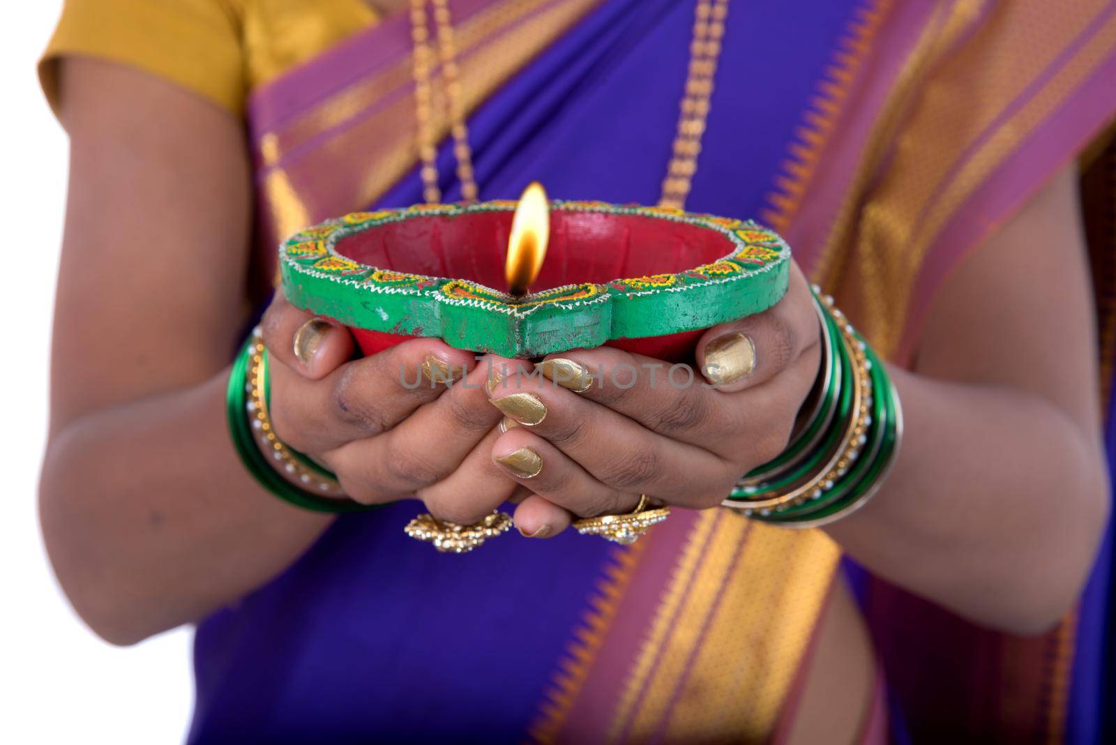 Portrait of a woman holding diya, Diwali or deepavali photo with female hands holding oil lamp during festival of light on white background