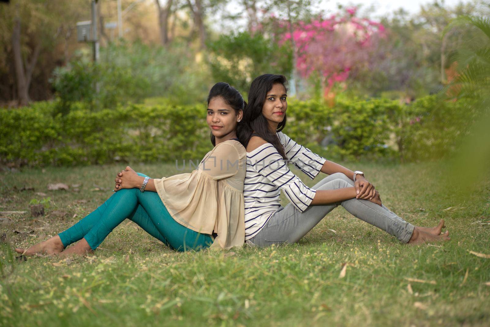 Two young girl friends having fun together in outdoors. Looking at camera.