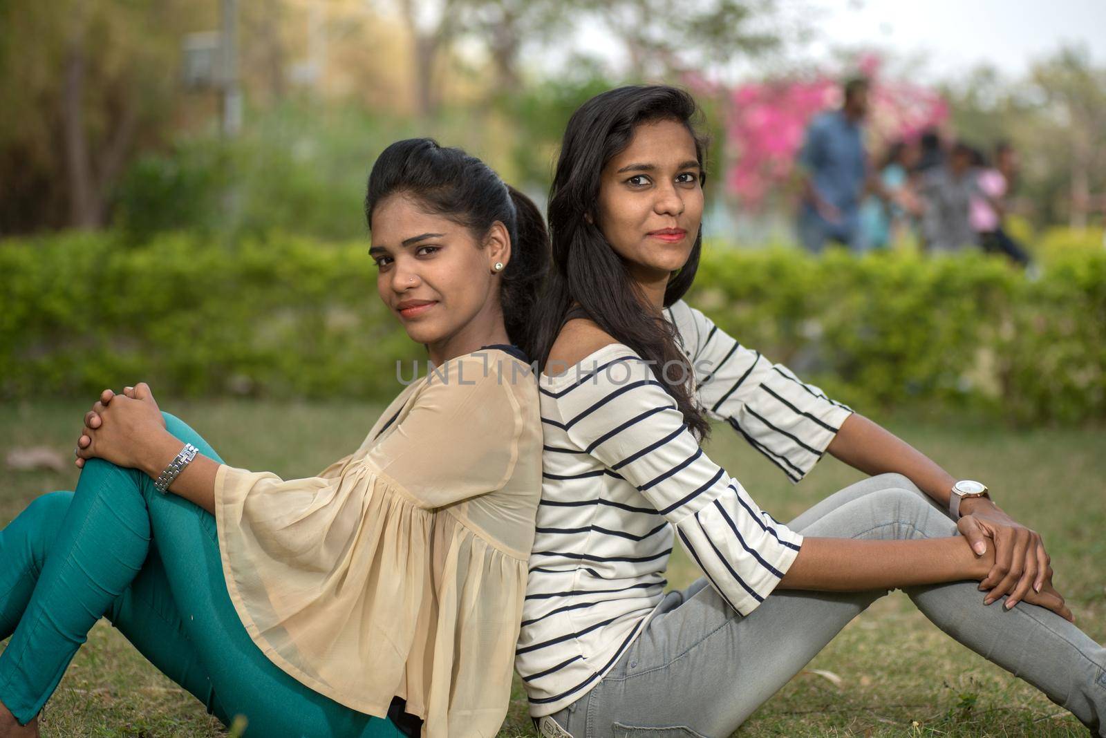 Two young girl friends having fun together in outdoors. Looking at camera.