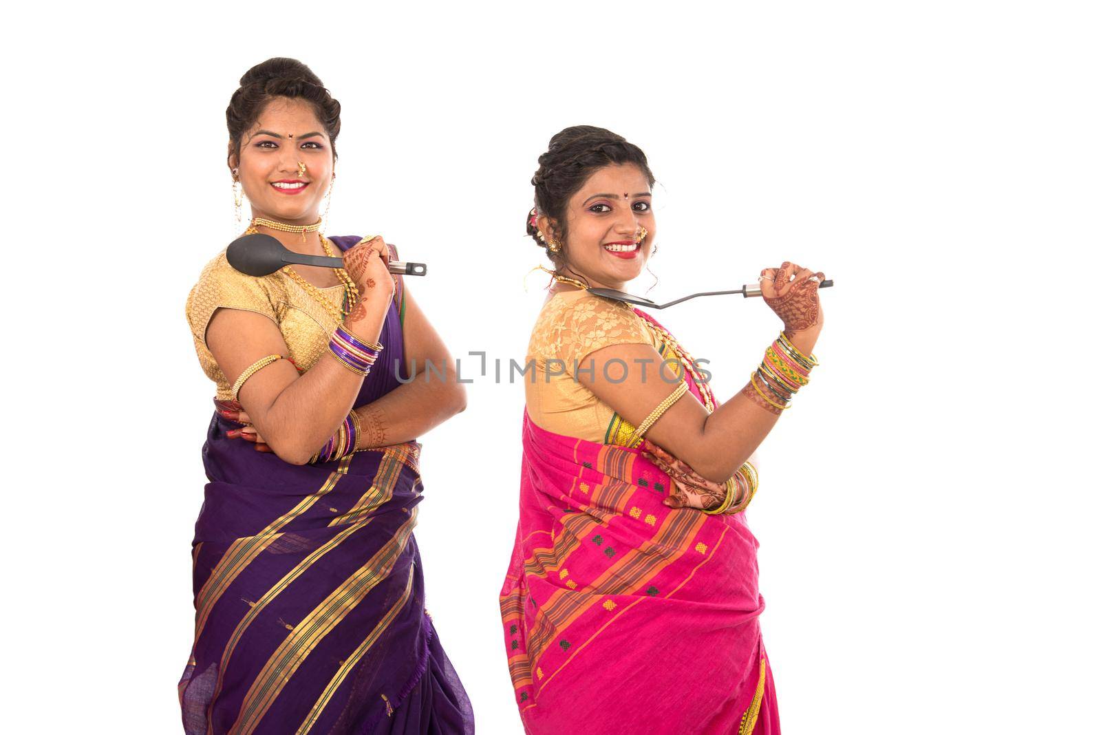 Young Traditional Indian Girls holding kitchen utensil on white background