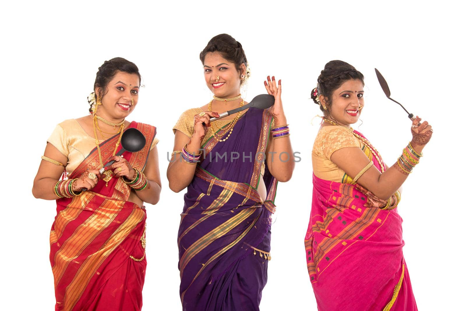 Young Traditional Indian Girls holding kitchen utensil on white background