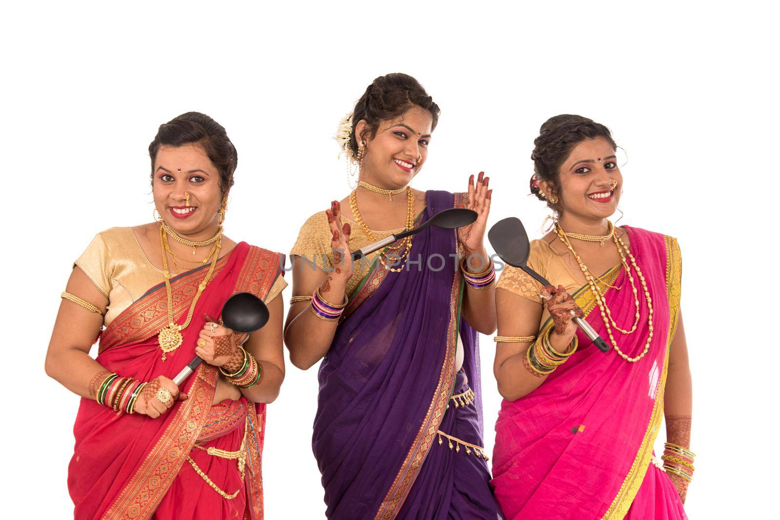 Young Traditional Indian Girls holding kitchen utensil on white background