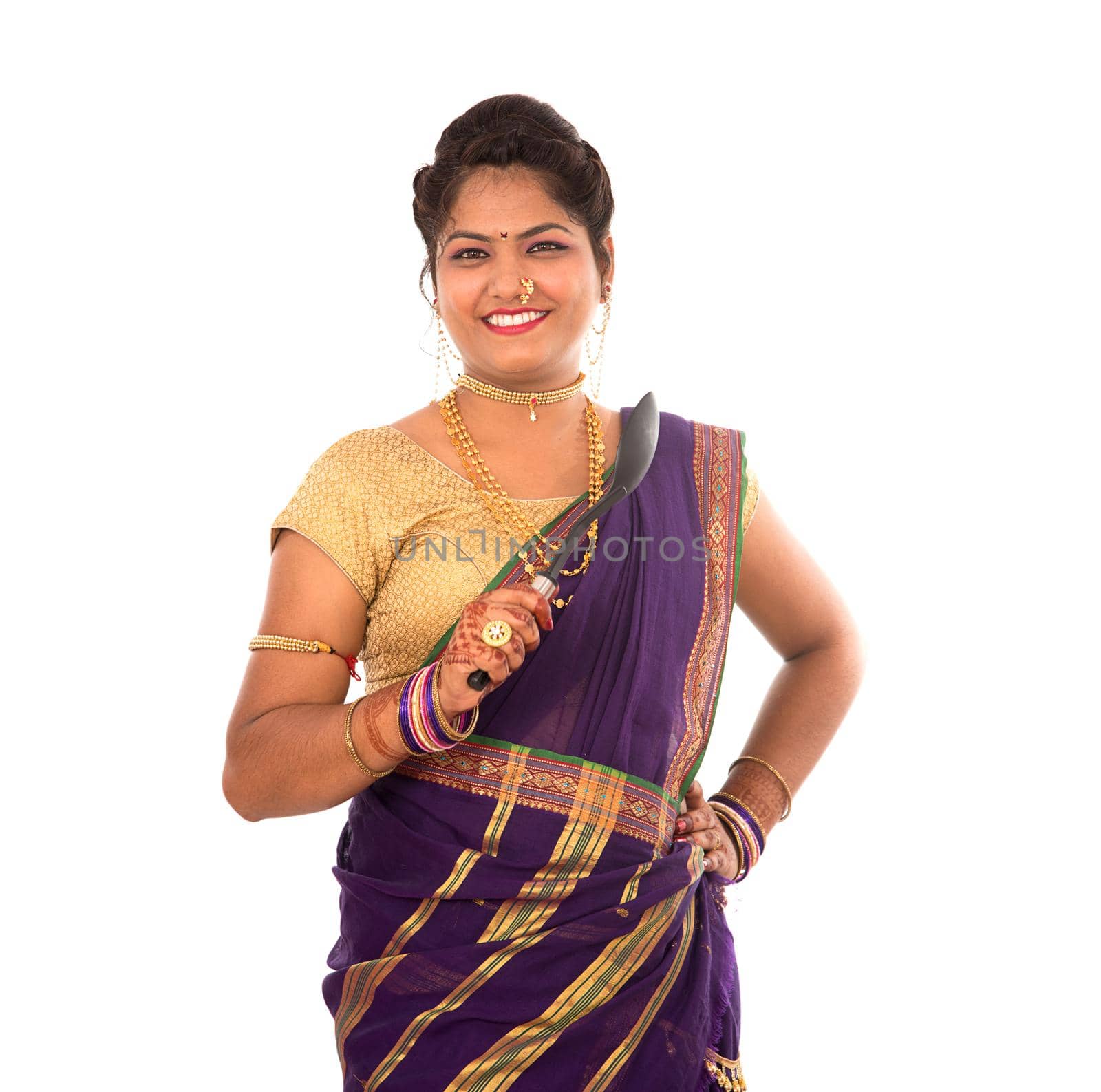 Young Traditional Indian Girl holding kitchen utensil on white background