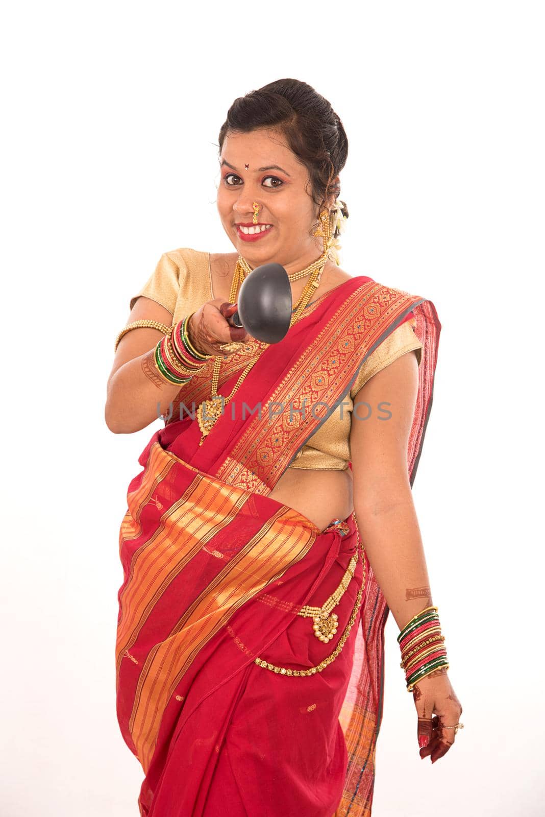 Young Traditional Indian Girl holding kitchen utensil on white background