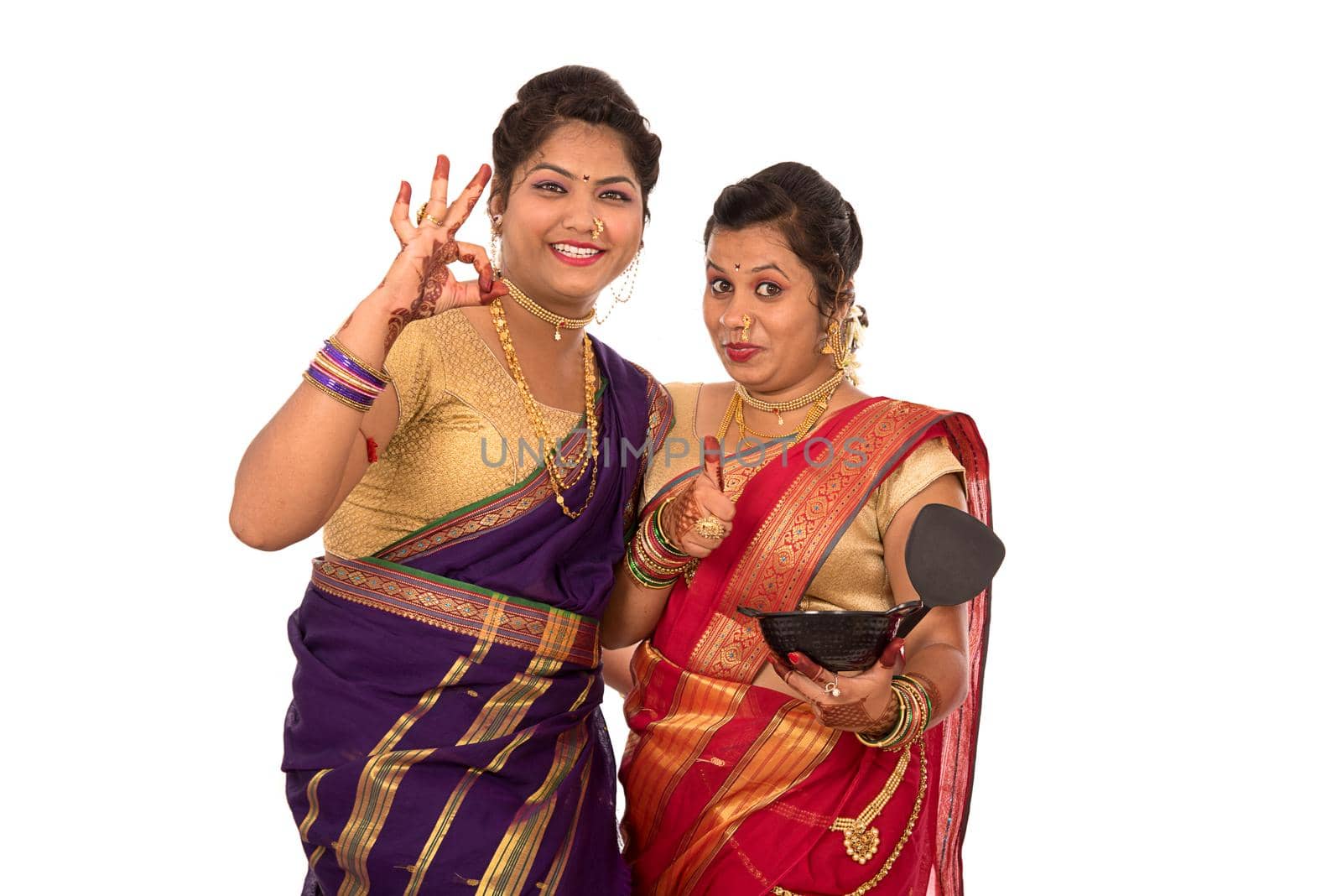 Young Traditional Indian Girls holding kitchen utensil on white background