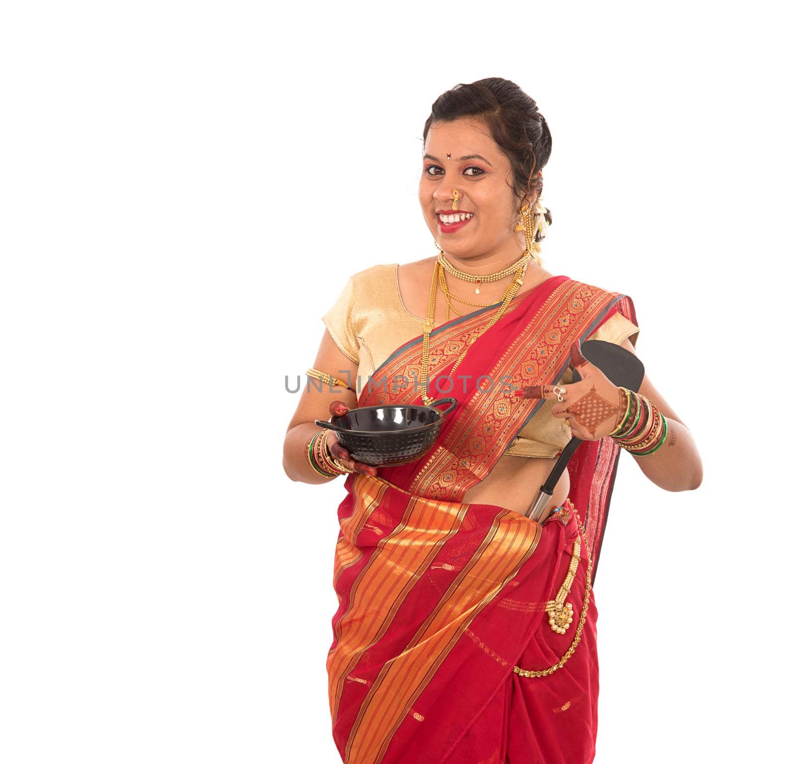 Young Traditional Indian Girl holding kitchen utensil on white background